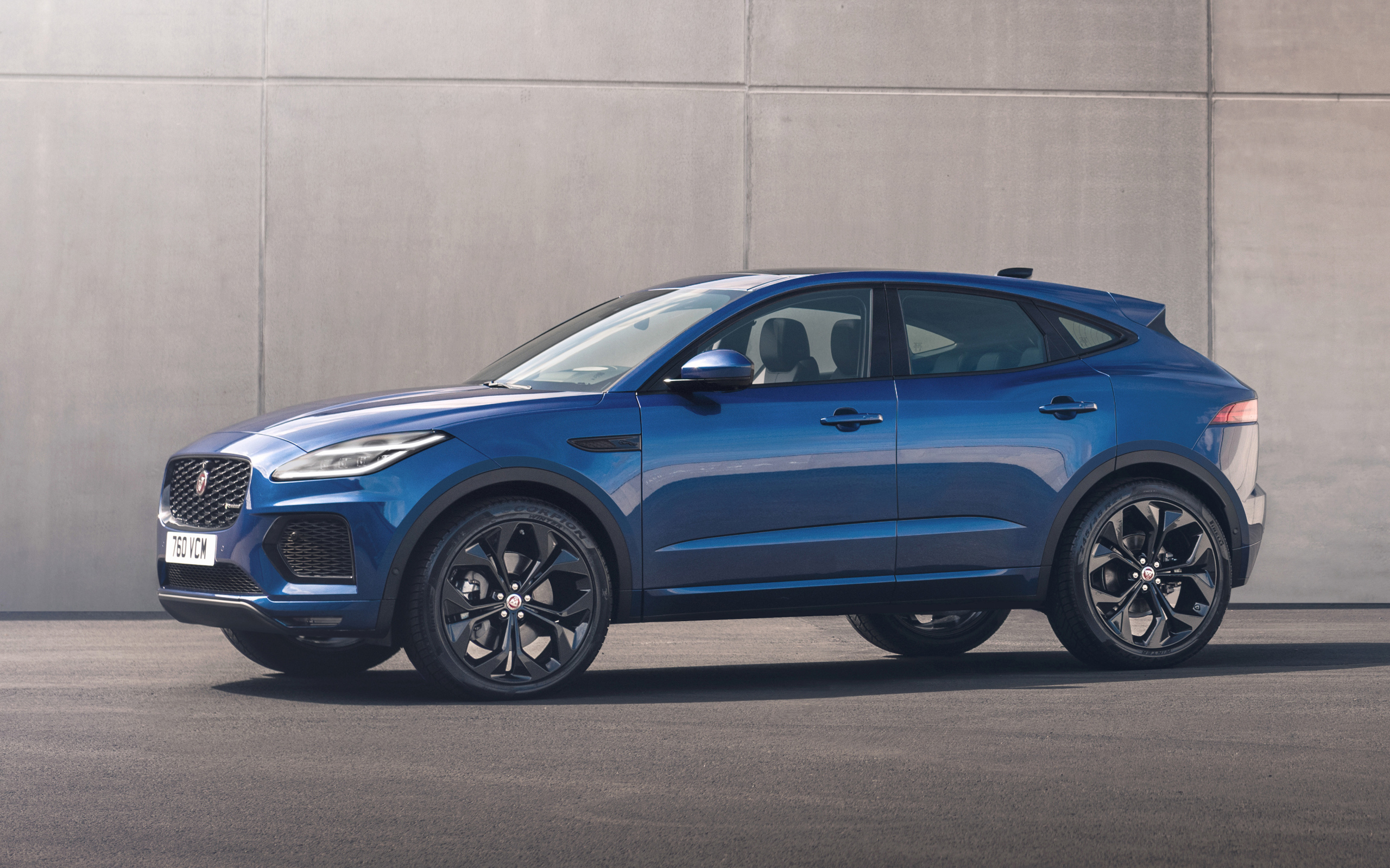 Синий Jaguar E-Pace R-Dynamic Black Pack 2021 года на фоне стены
