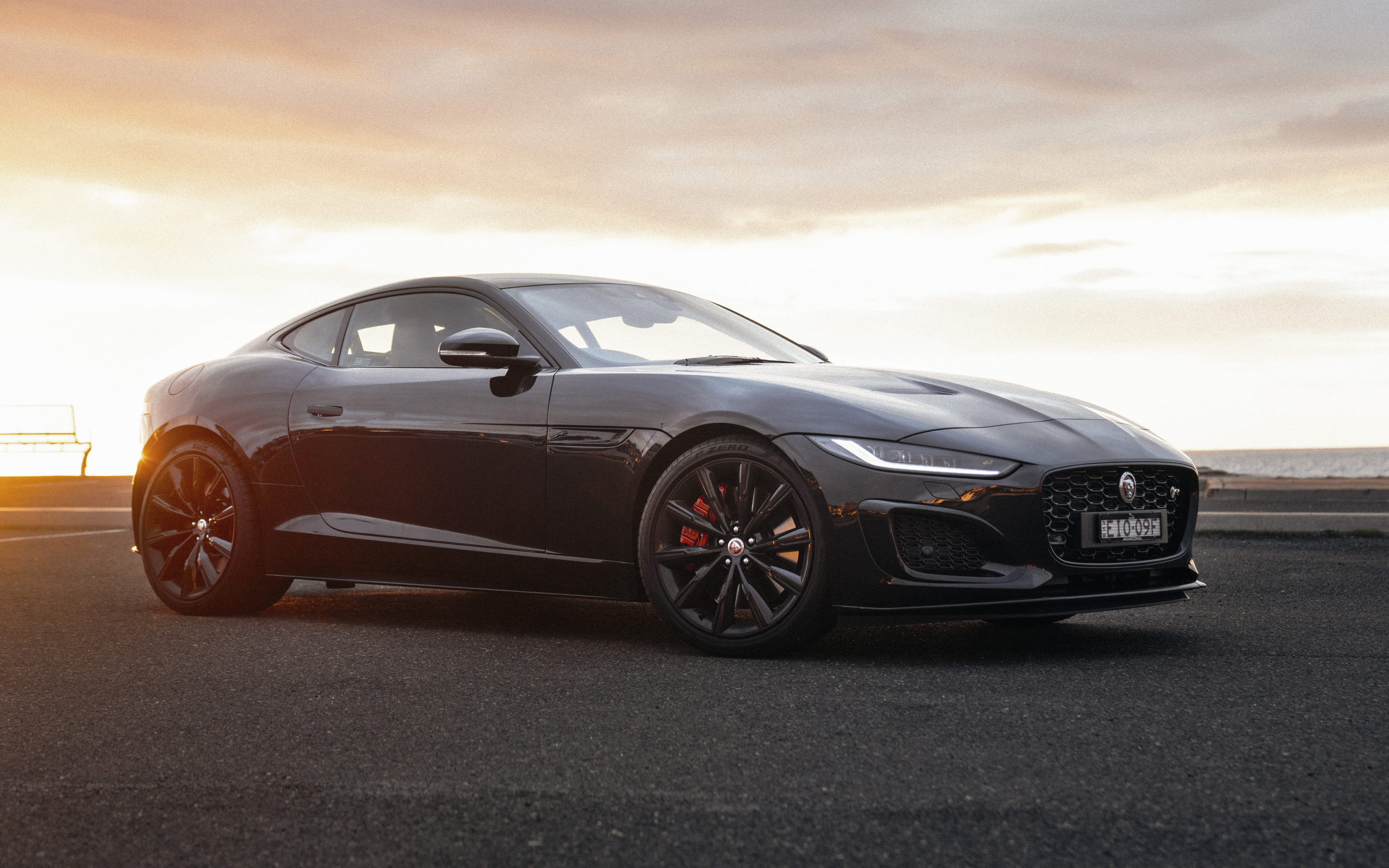 Черный автомобиль Jaguar F-Type R Coupé в лучах солнца