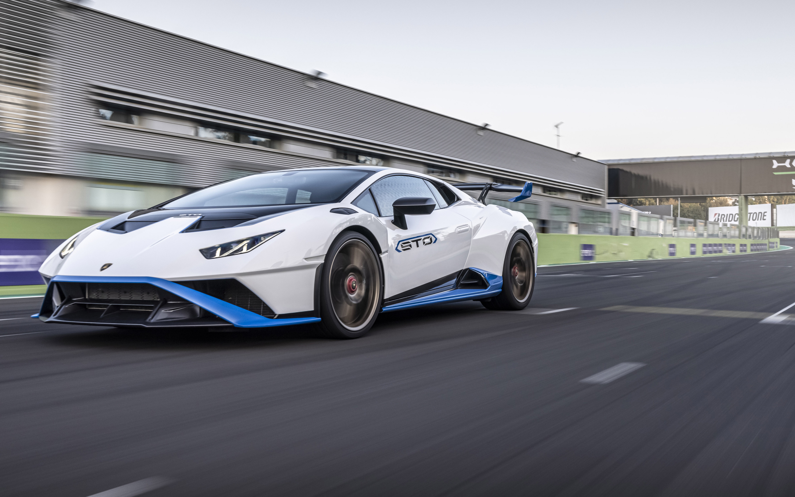 Белый автомобиль Lamborghini Huracán STO 2021 года на стадионе 