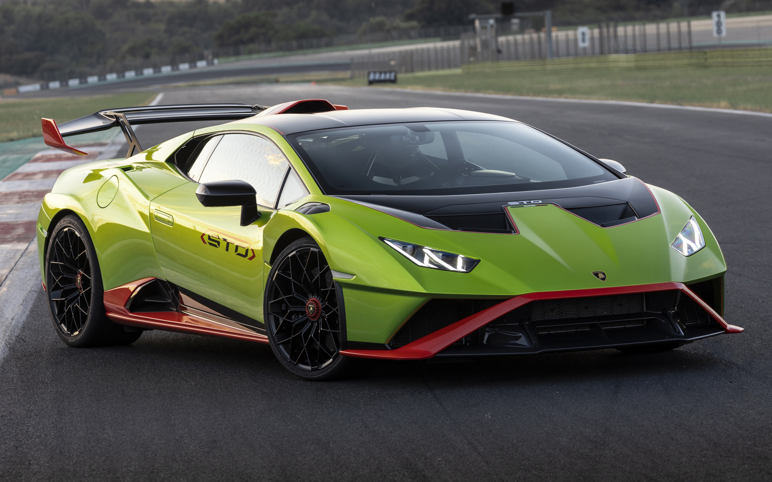 Зеленый автомобиль Lamborghini Huracán STO 2021 года на дороге