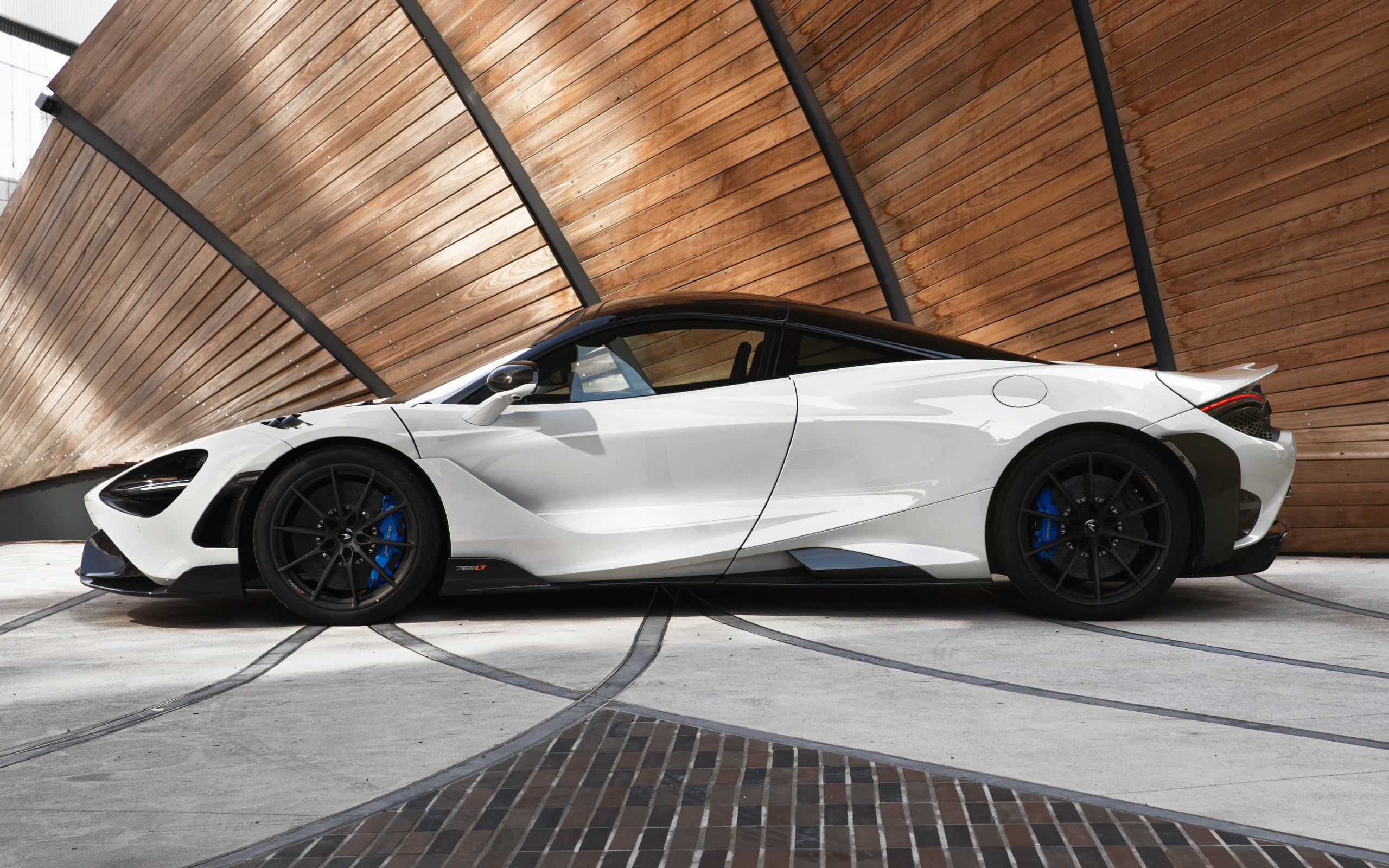 Белый автомобиль  McLaren 765LT, 2021 года вид сбоку