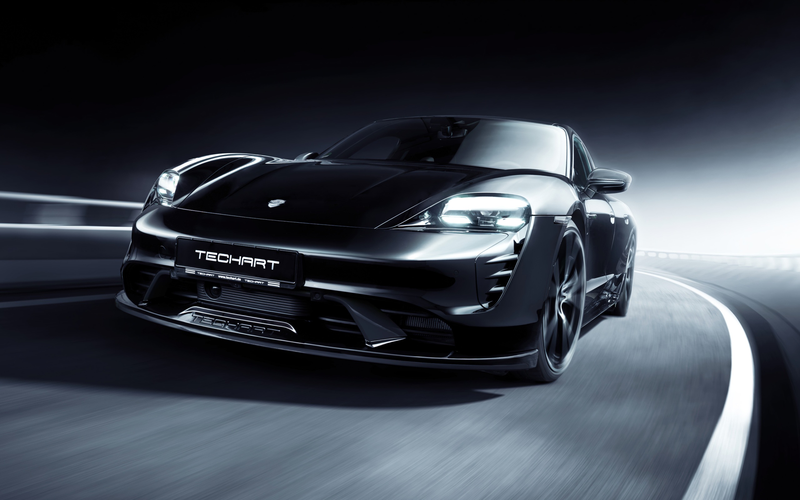 Черный Porsche Taycan Aerokit 2021 года на трассе