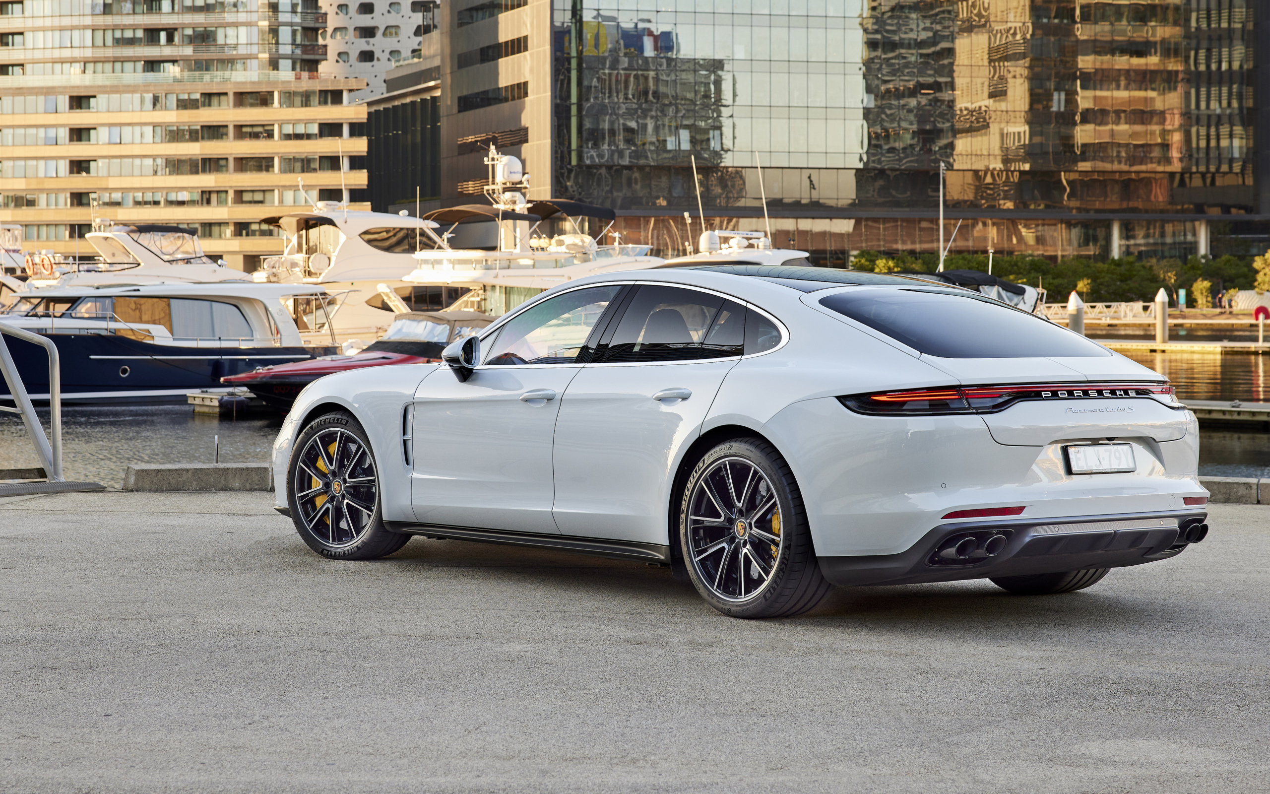 Белый автомобиль Porsche Panamera Turbo S 2021 года вид сзади