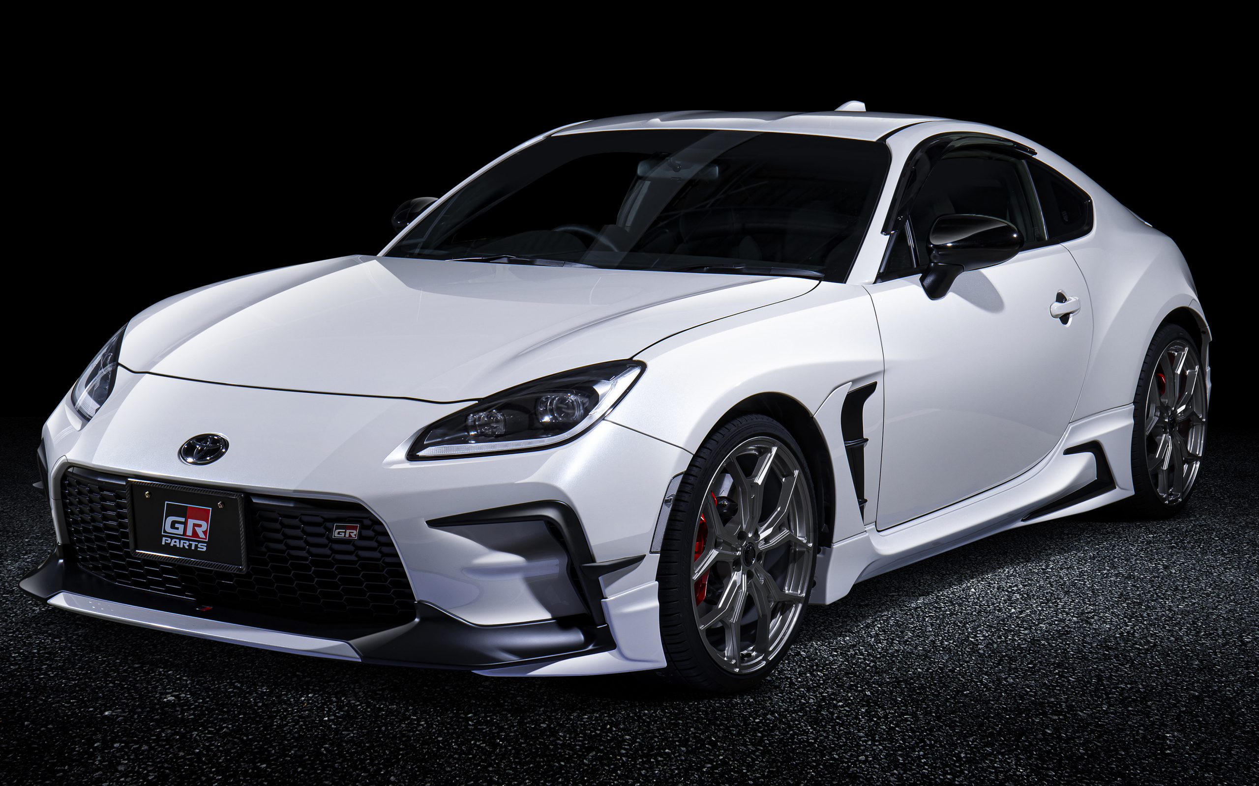 Белый автомобиль Toyota GR 86 GR With GR Parts 2021 года на черном фоне