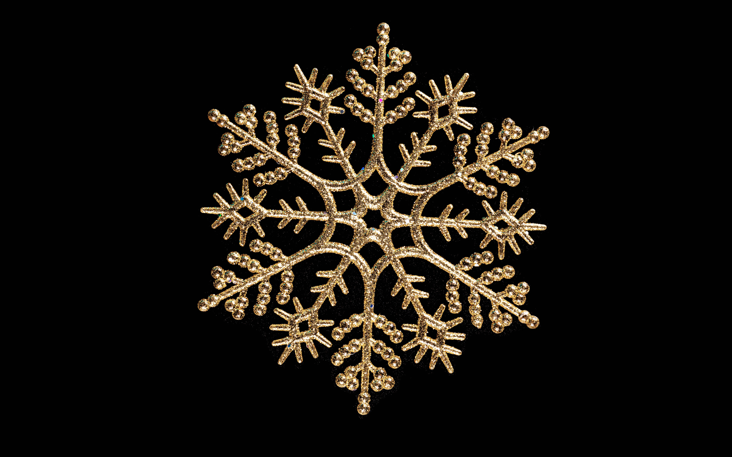 Красивая золотистая снежинка на черном фоне