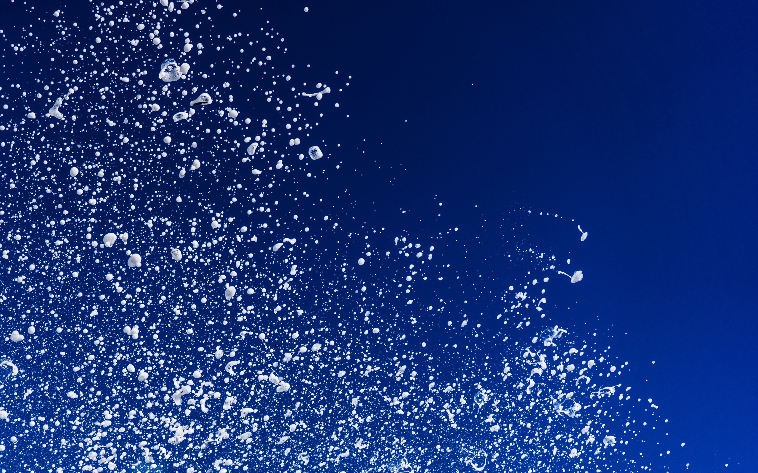 Белые брызги воды на синем фоне 