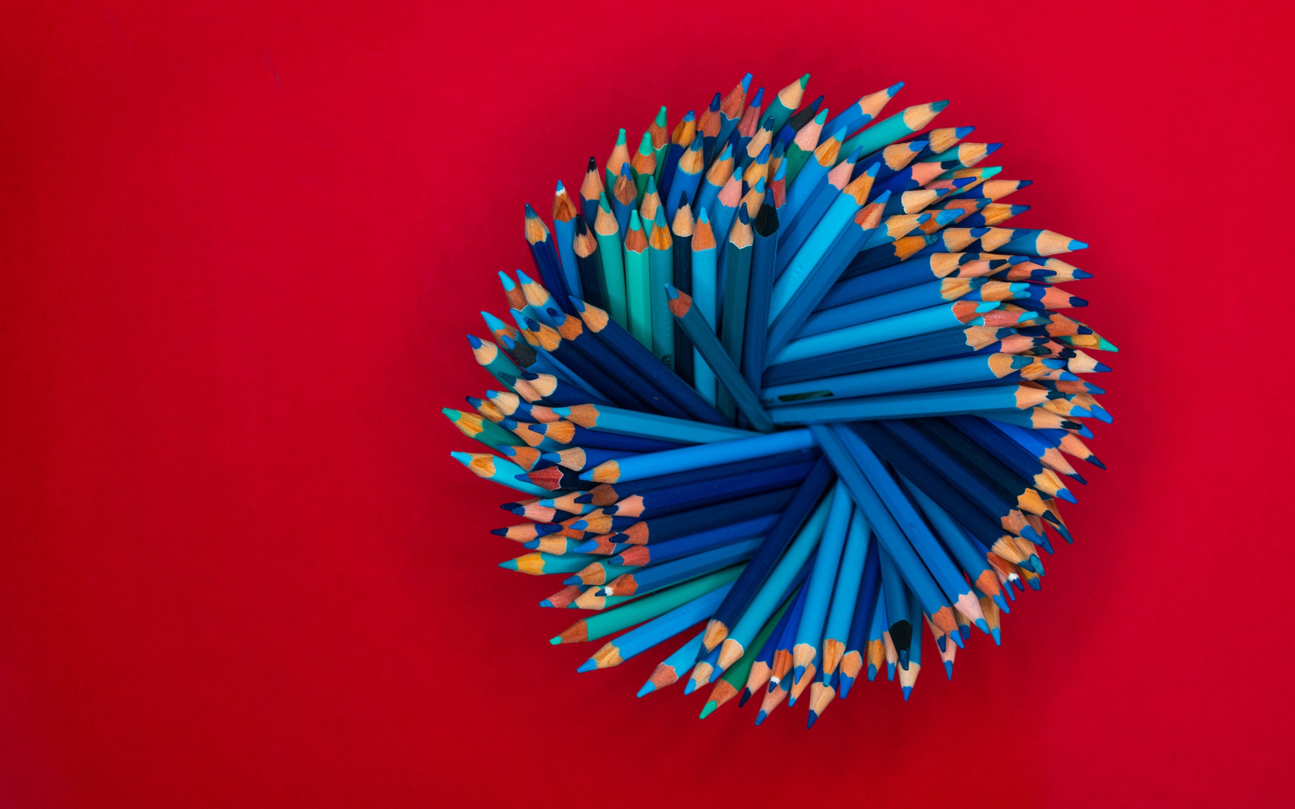 Синие карандаши на красном фоне