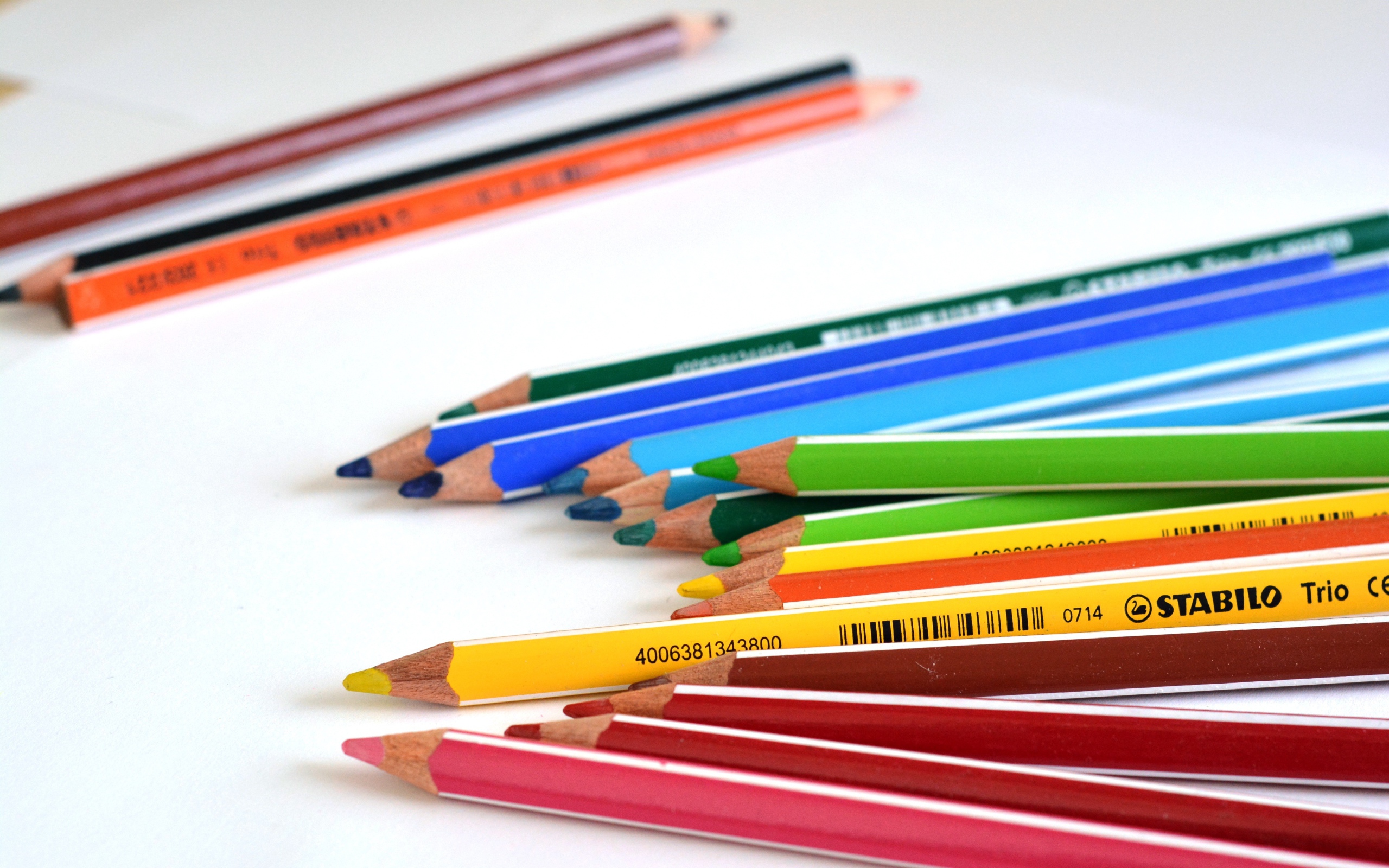 Разноцветные карандаши на белом столе 