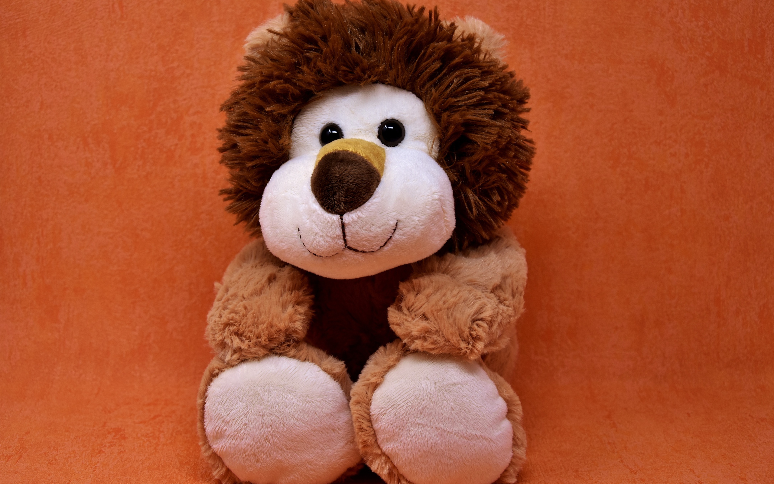 Игрушечный лев на фоне стены