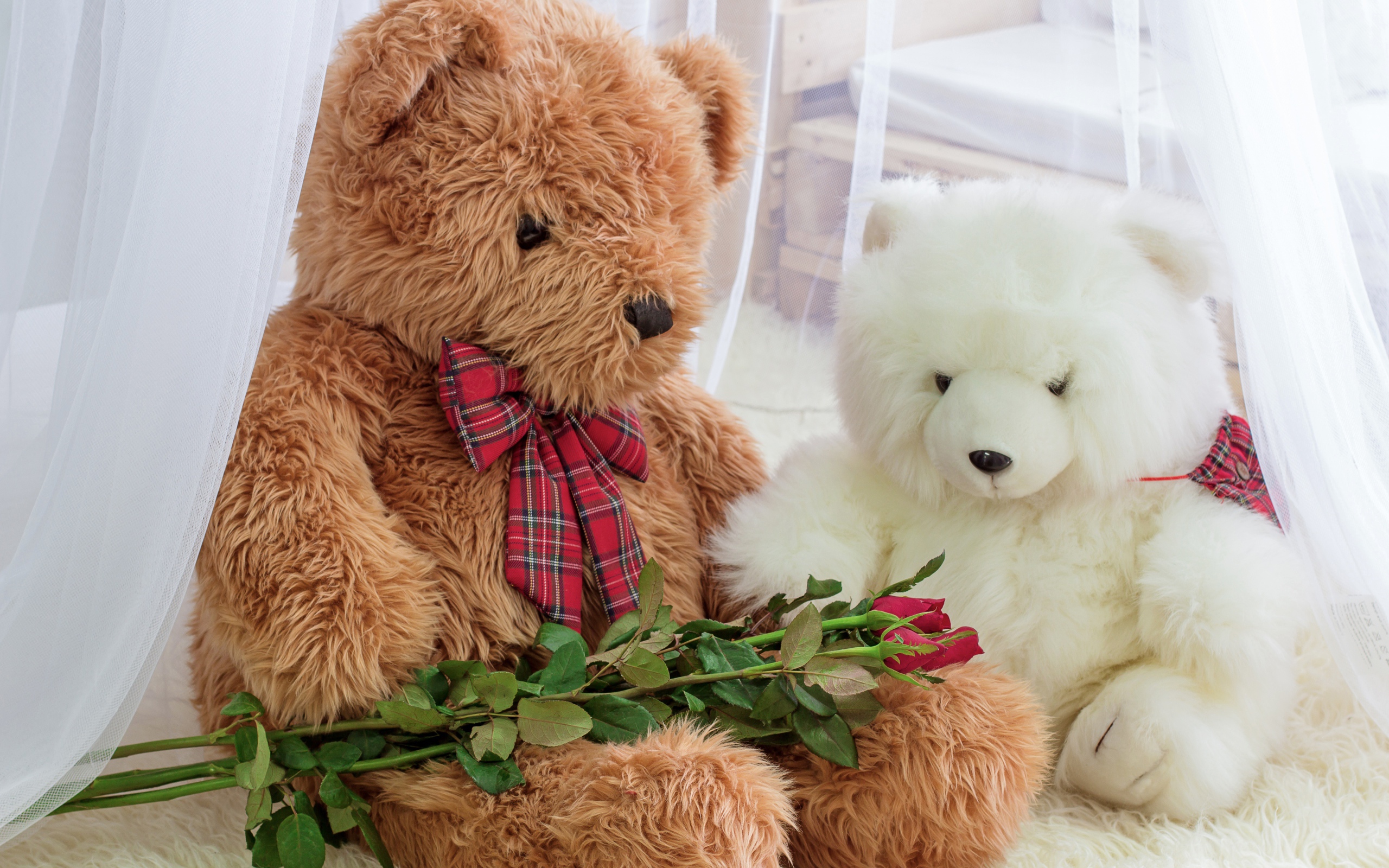 Two big toy bears with a bouquet of roses