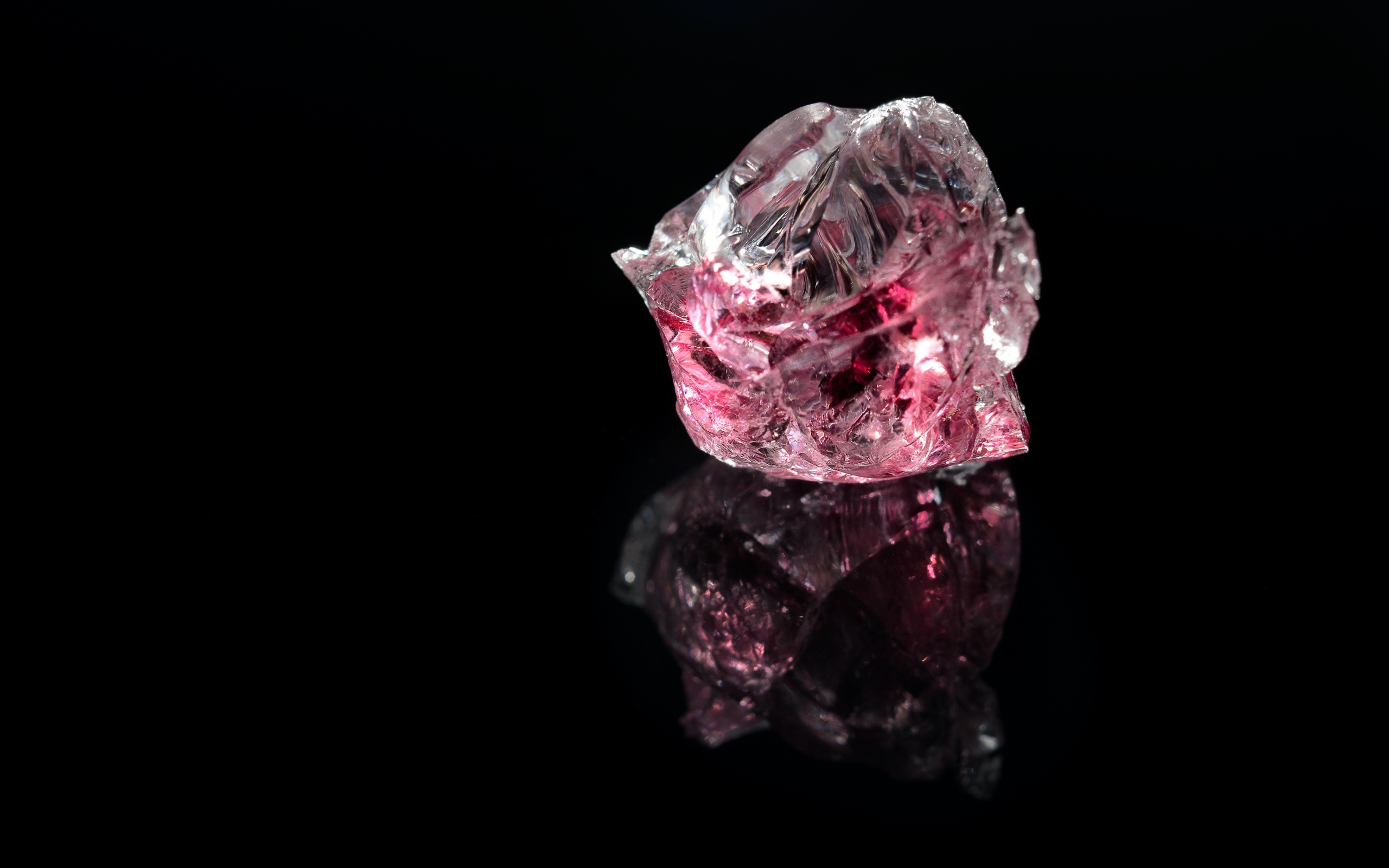 Розовый драгоценный камень на черном фоне 