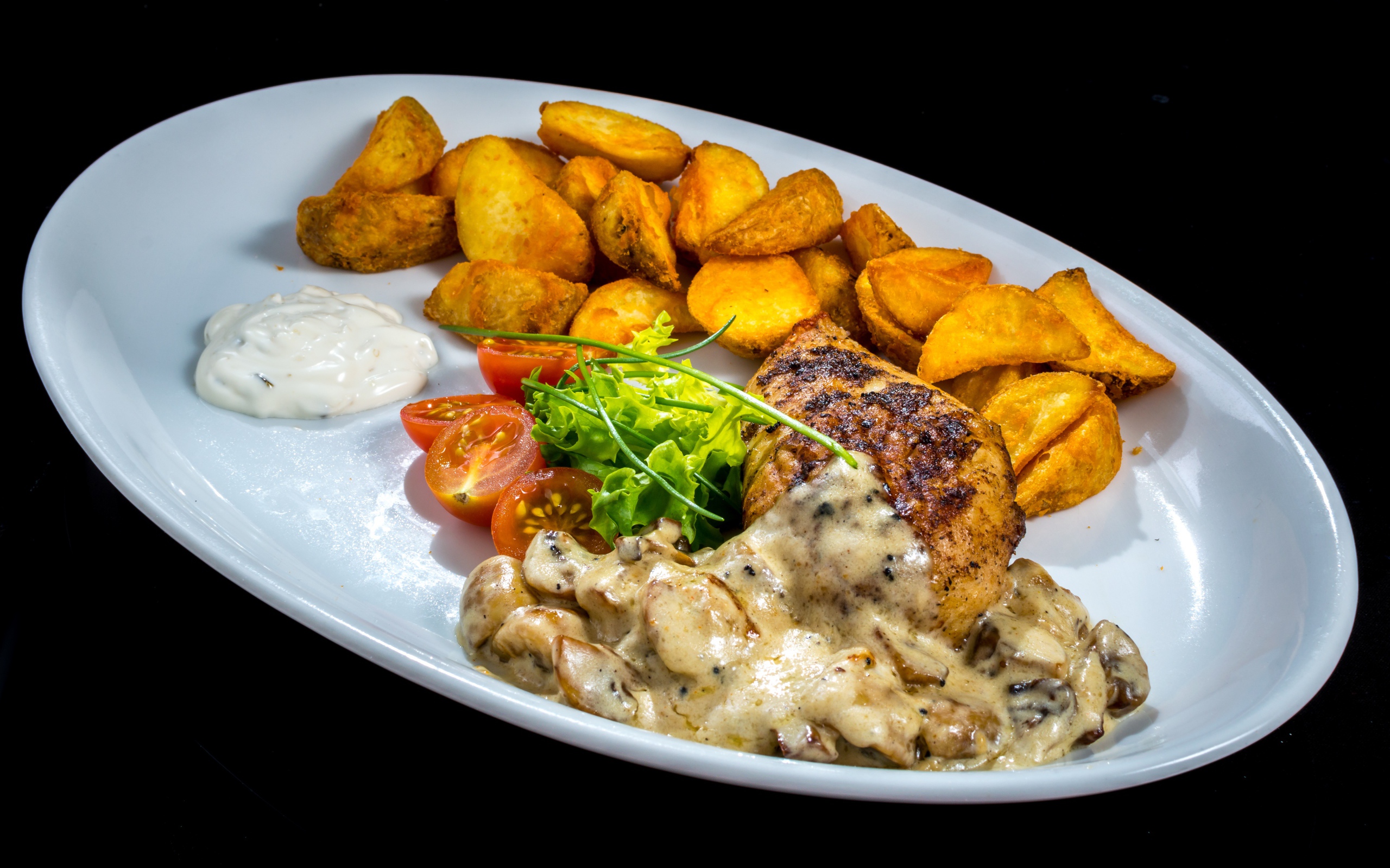 Запеченный картофель с грибами, мясом и овощами на тарелке