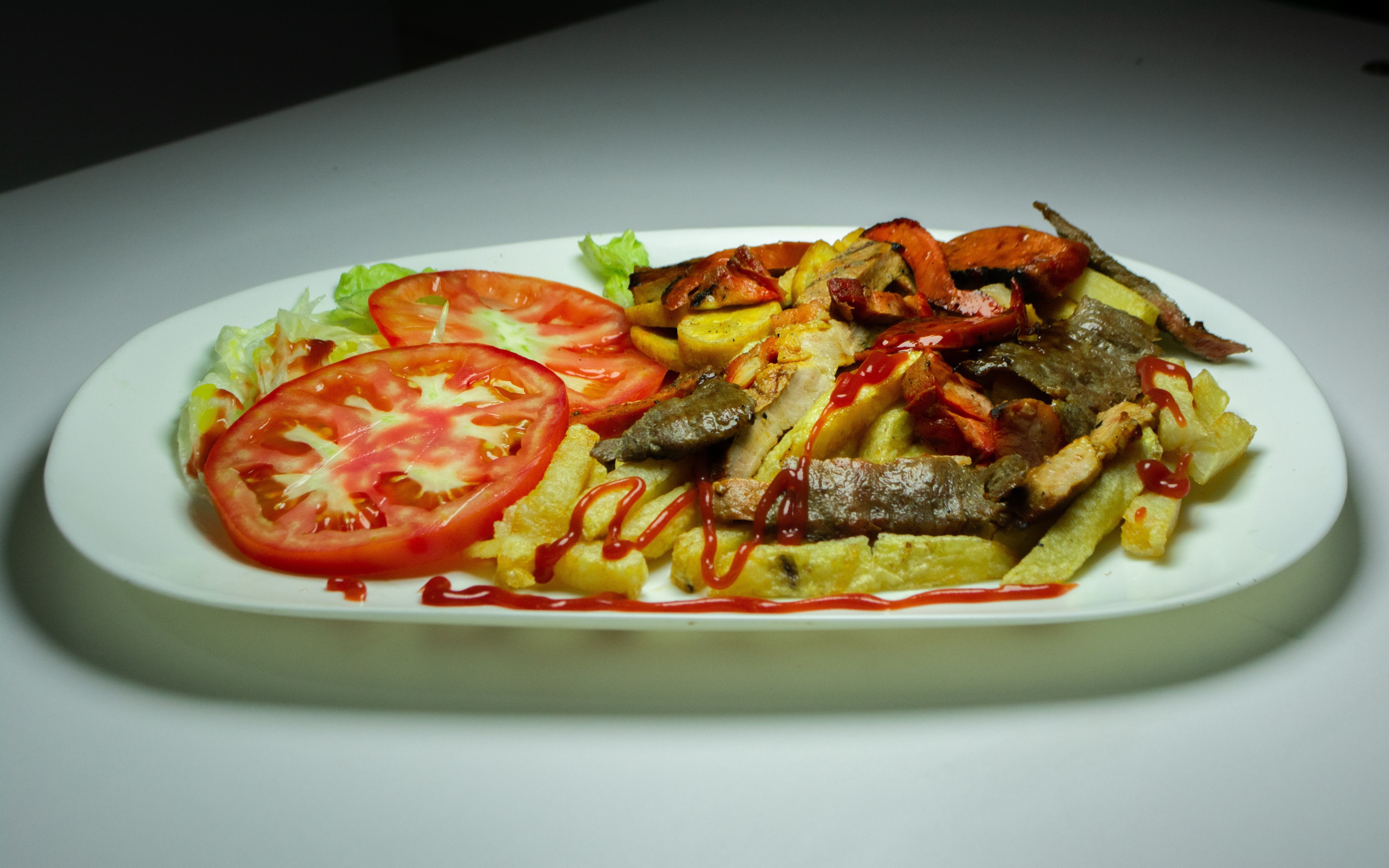 Картофель фри на тарелке с помидорами 