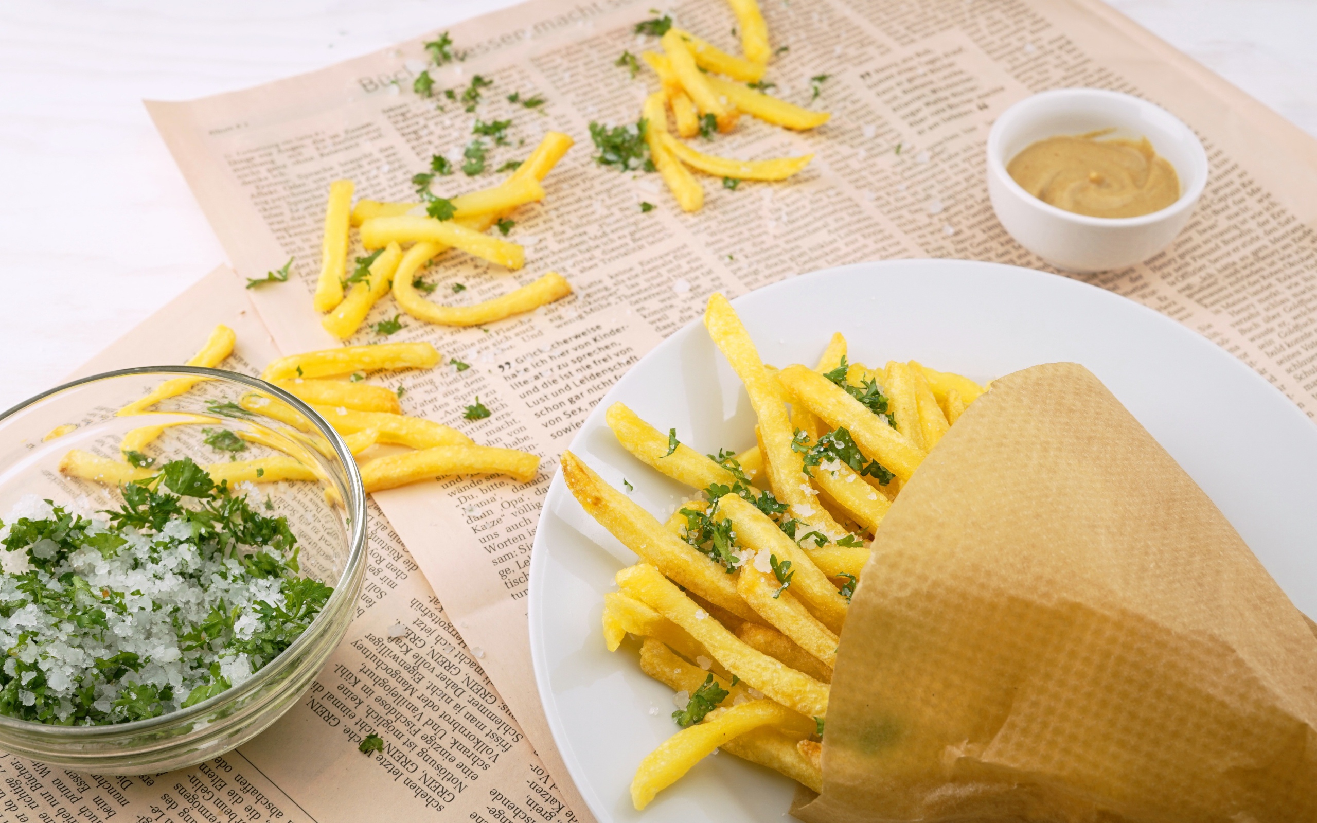 Картофель фри с зеленью на газете