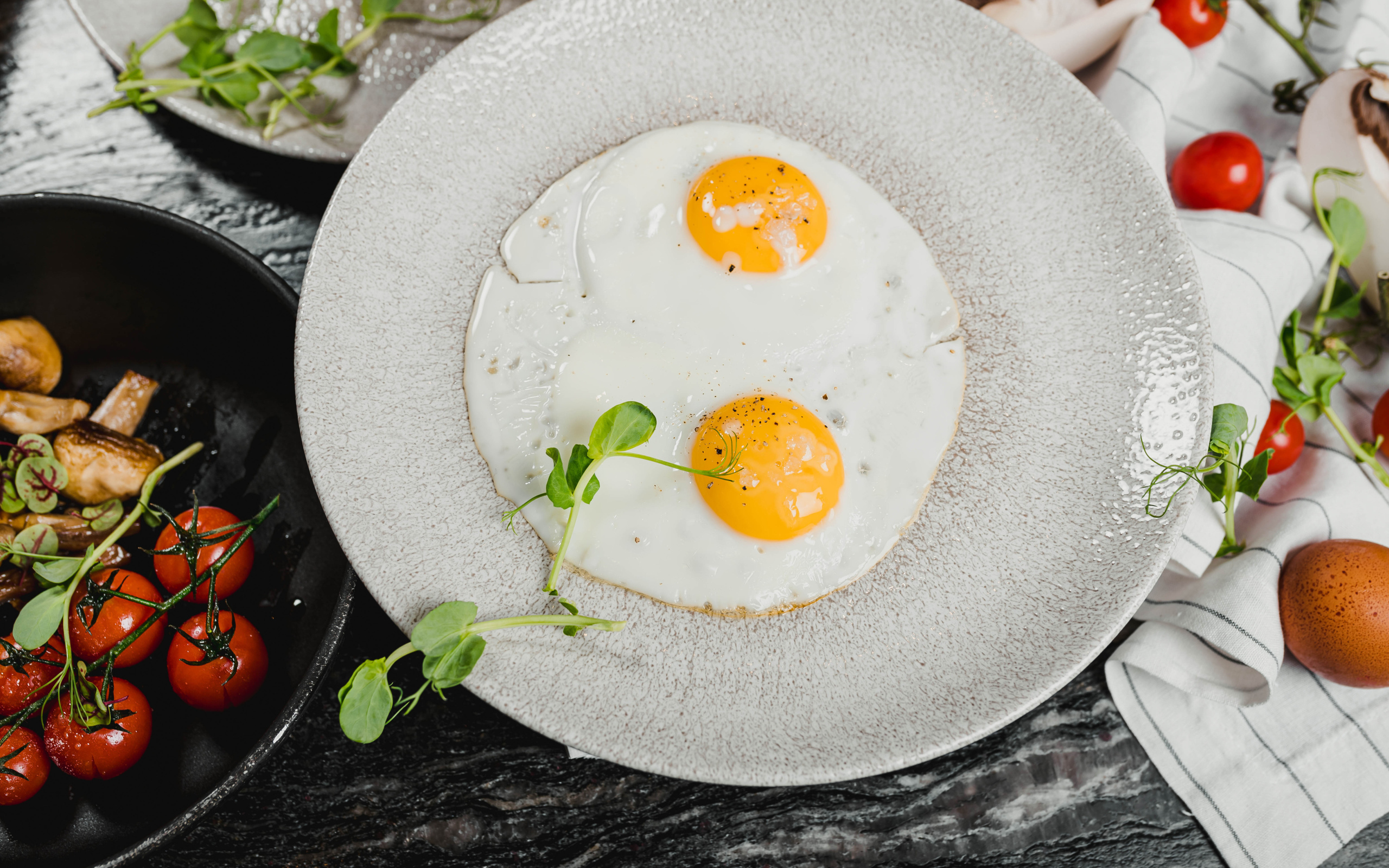 Яичница глазунья на большой серой тарелке
