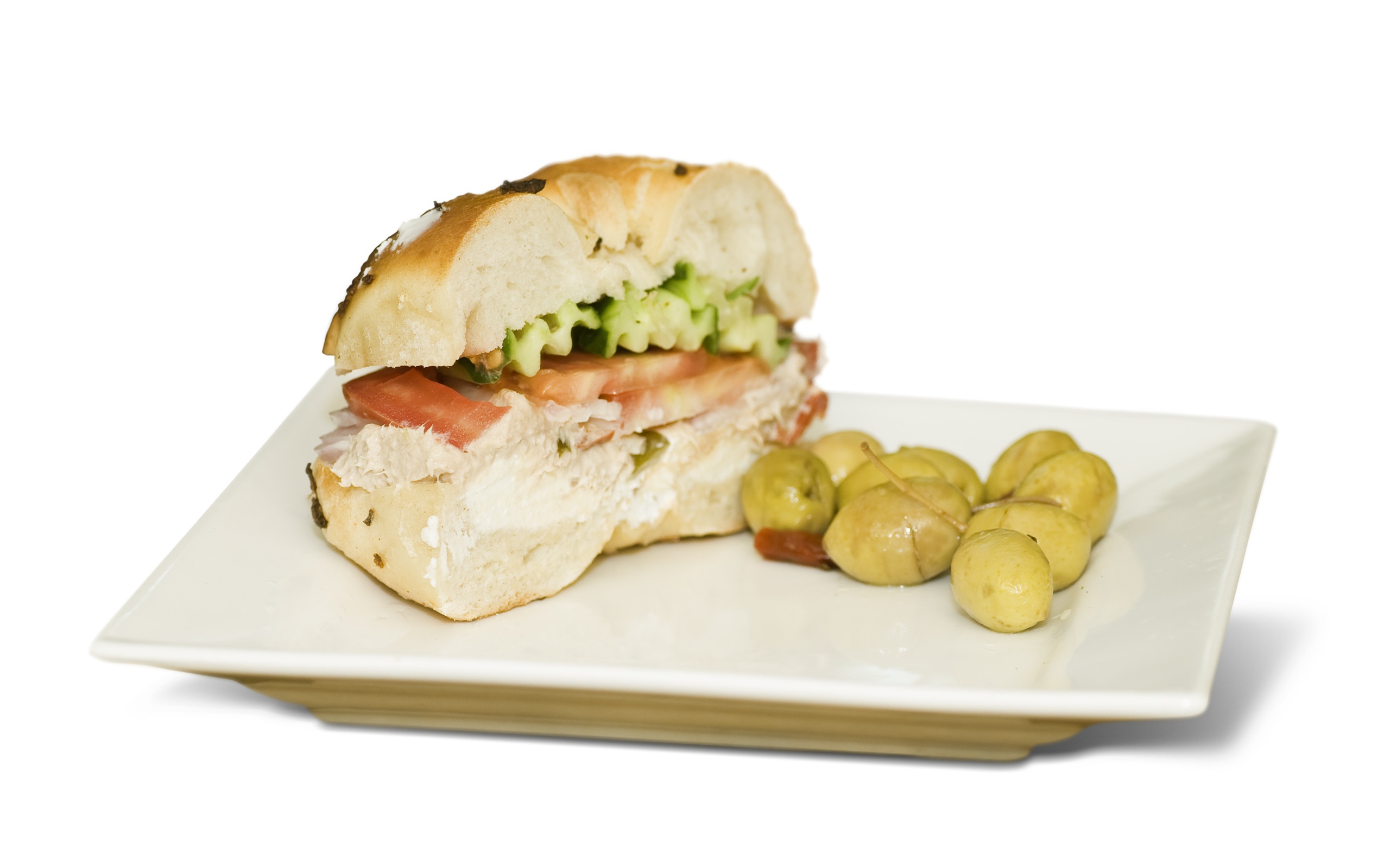 Половина гамбургера на тарелке с оливками