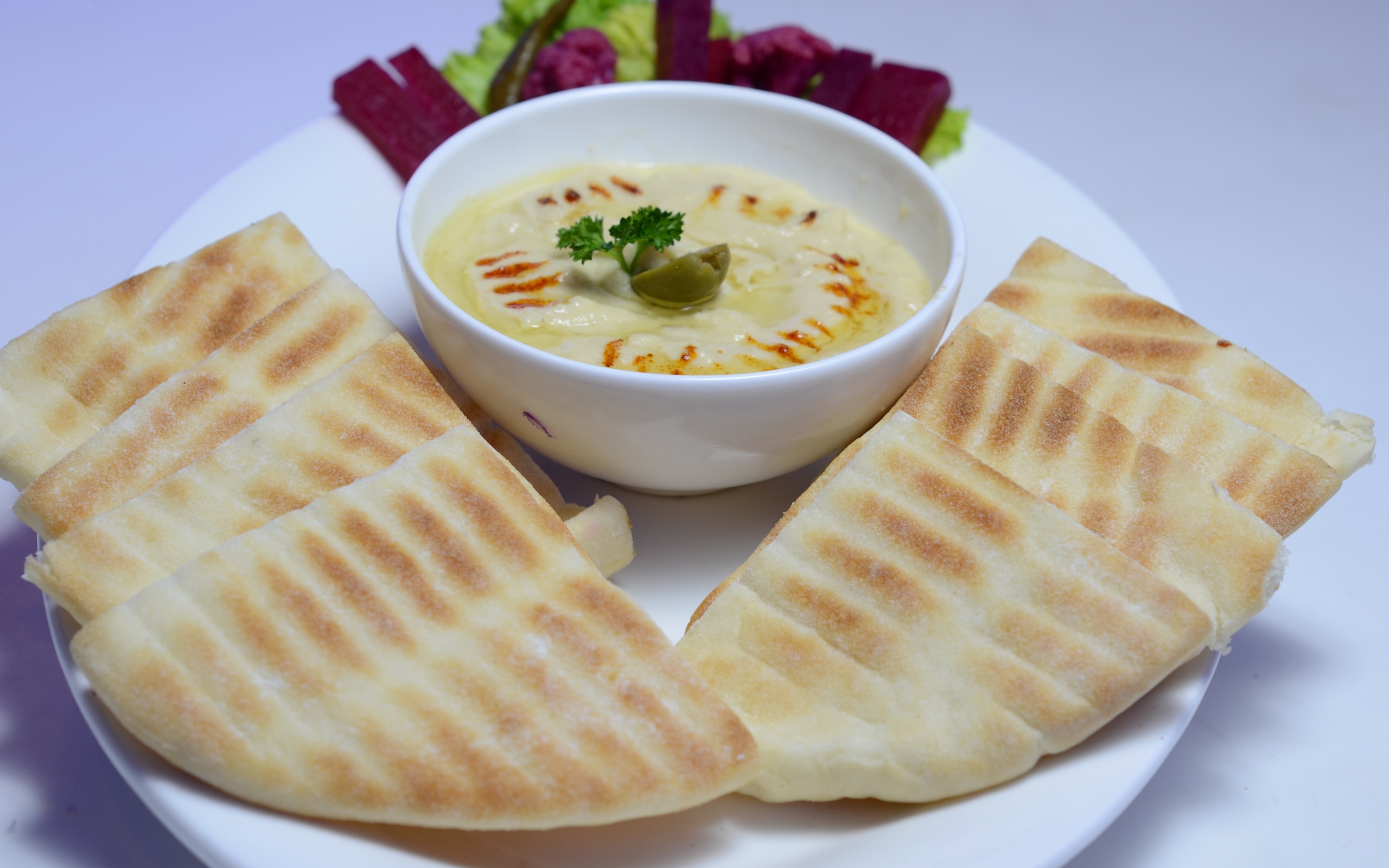 Хумус в белой тарелке с лавашом