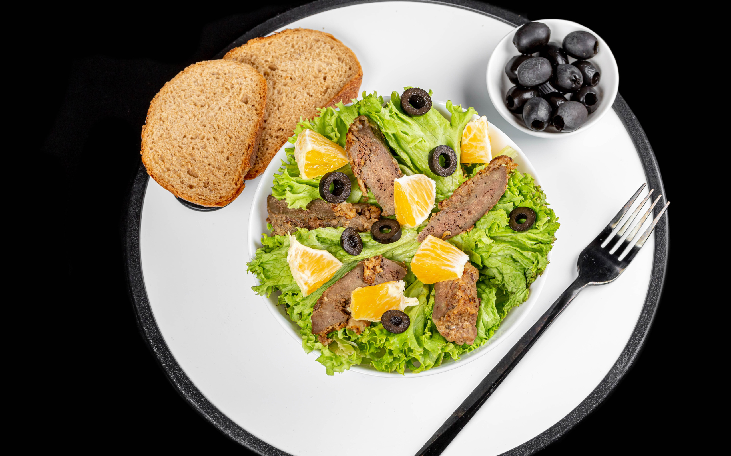 Листья салата с мясом на столе с хлебом