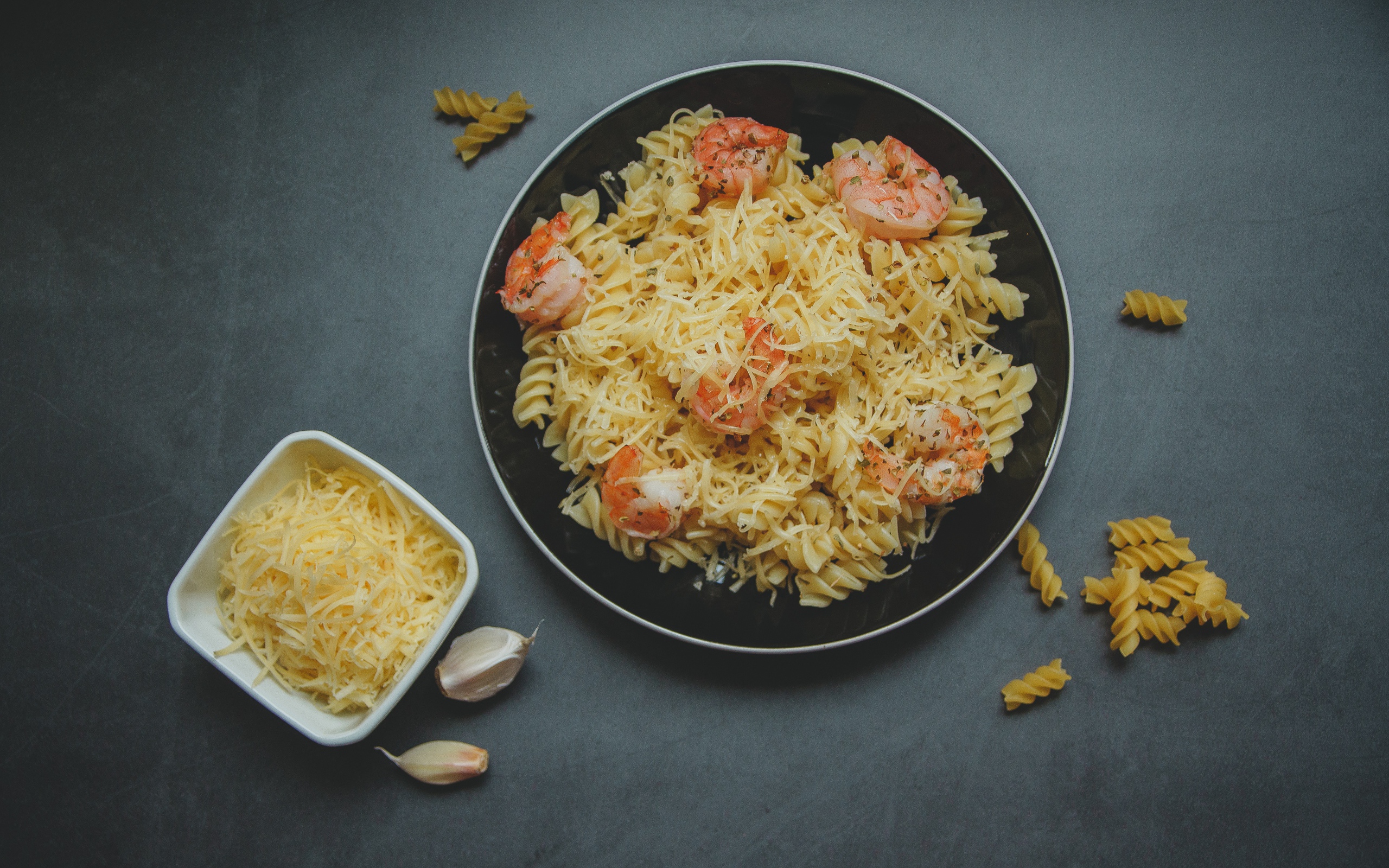 Макароны на тарелке с сыром и креветками