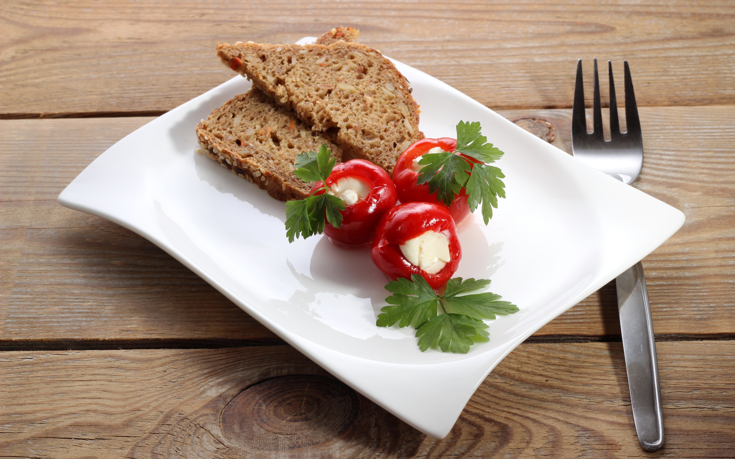 Фаршированный перец на большой белой тарелке с хлебом