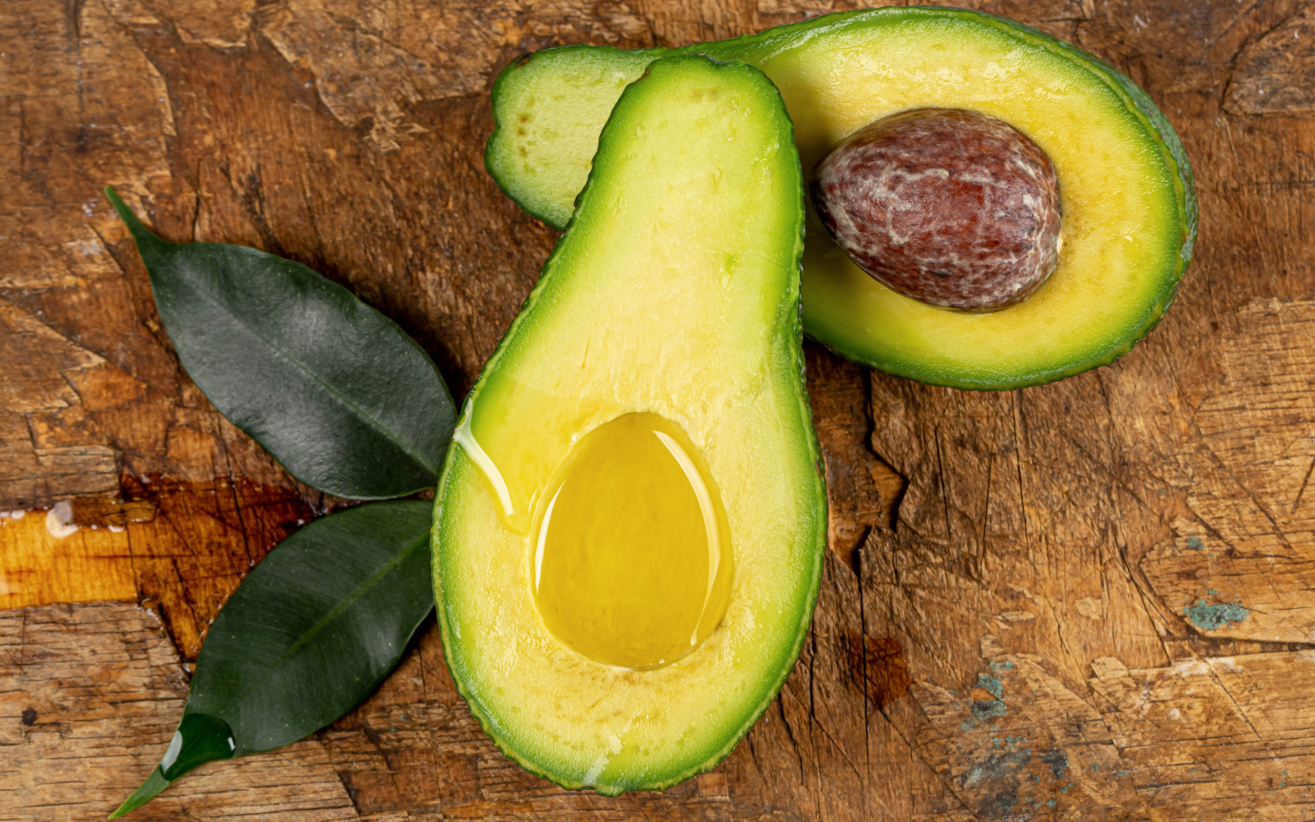 Зеленое авокадо на деревянном столе