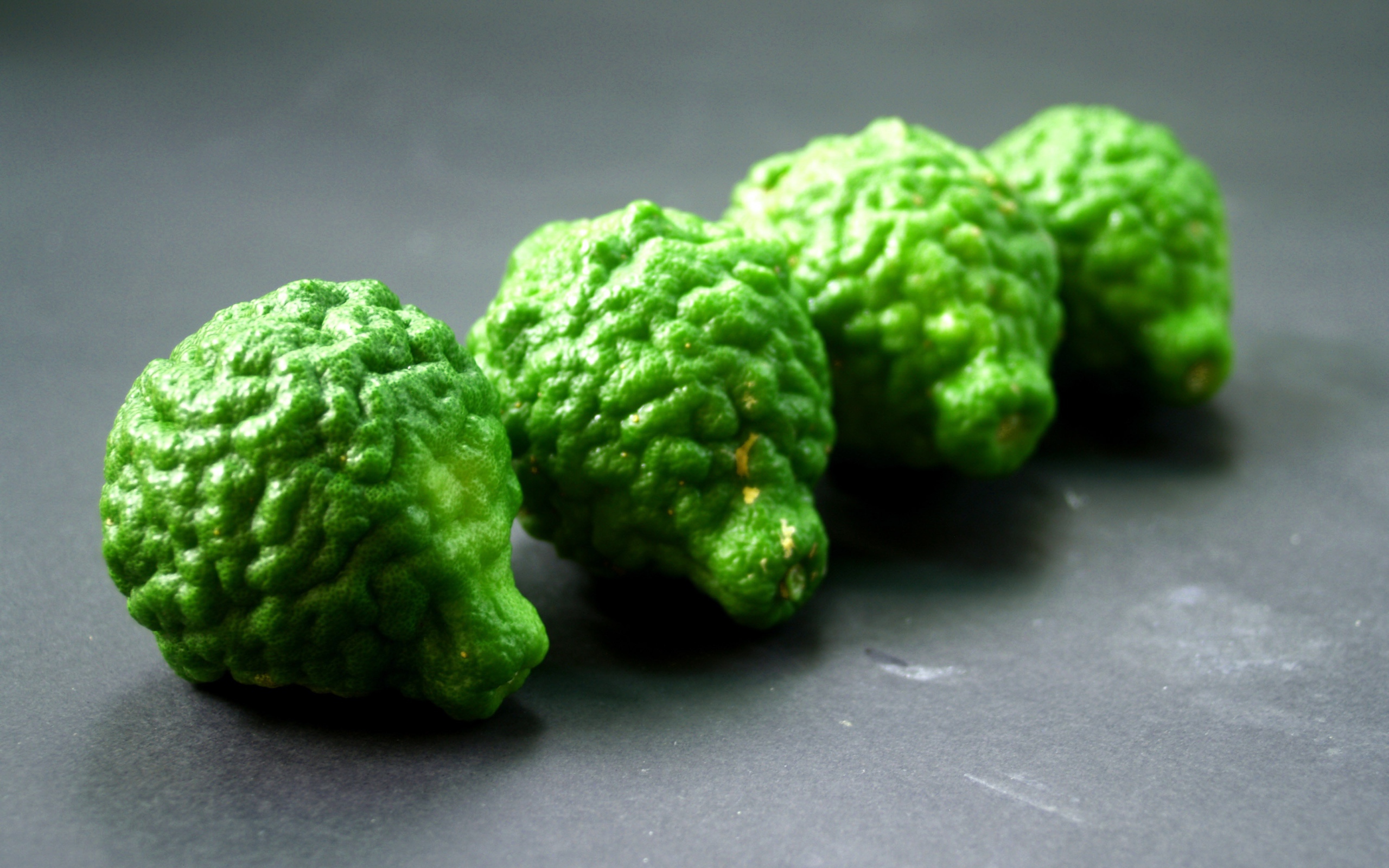 Зеленые плоды бергамота на серой поверхности