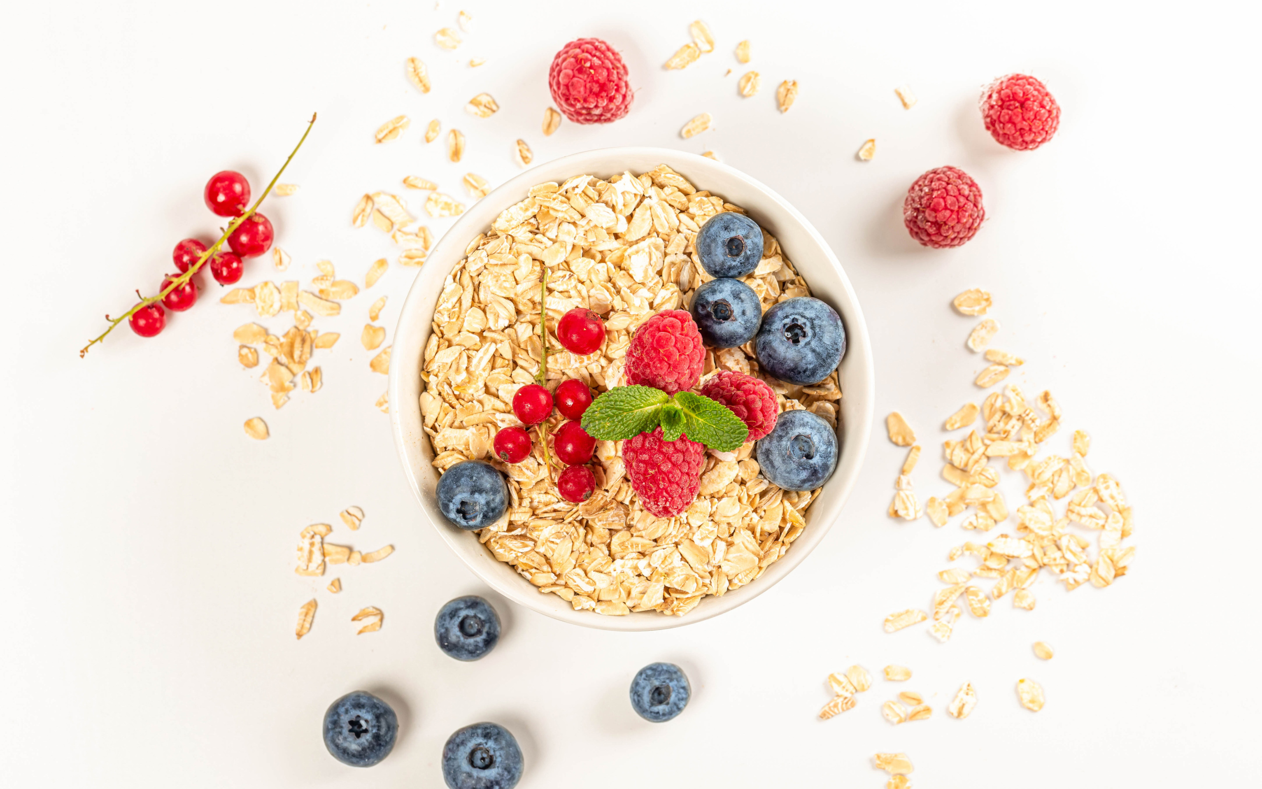 Овсяные хлопья с ягодами черники и малины на белом фоне 