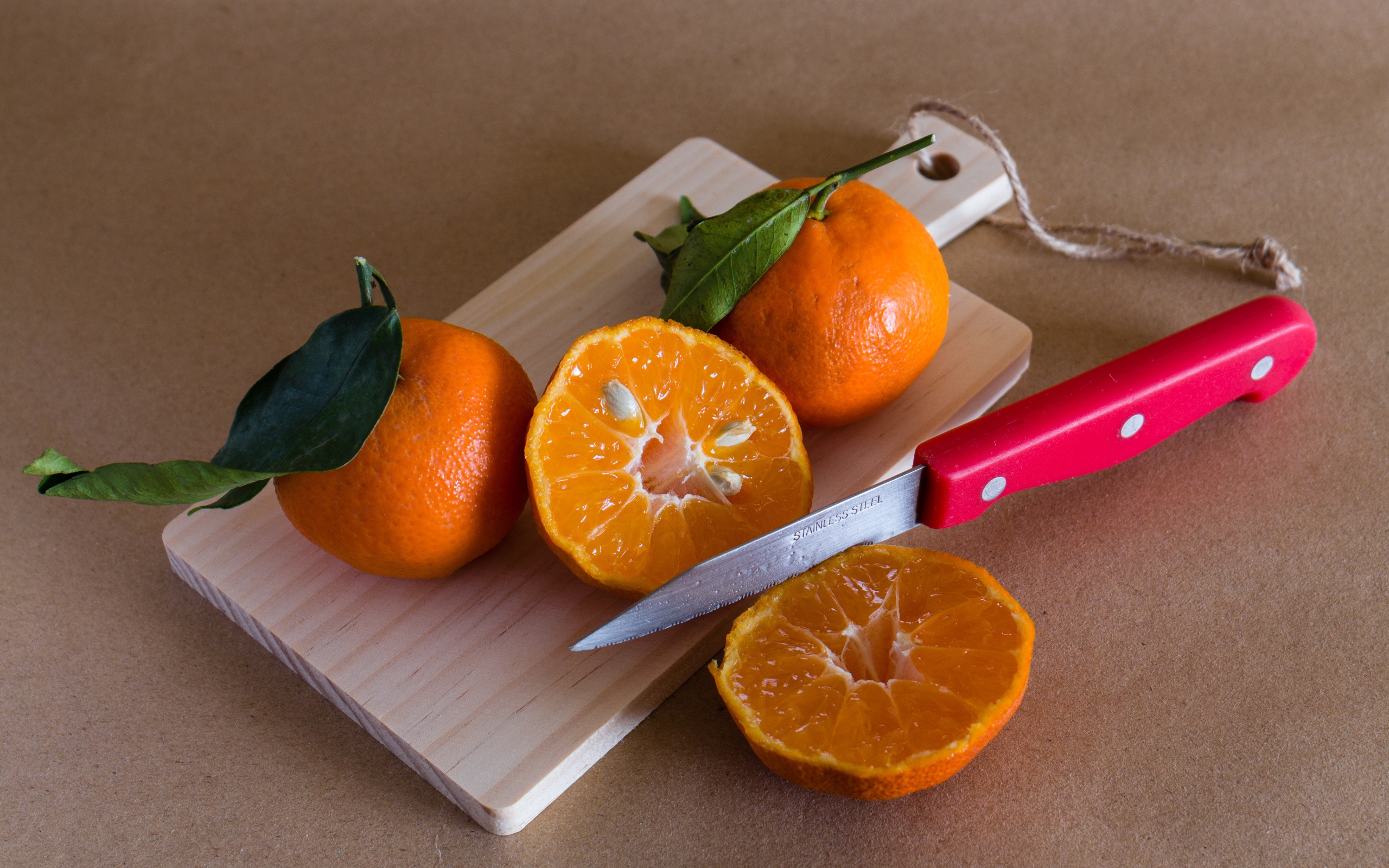 Мандарины лежат на доске с ножом 