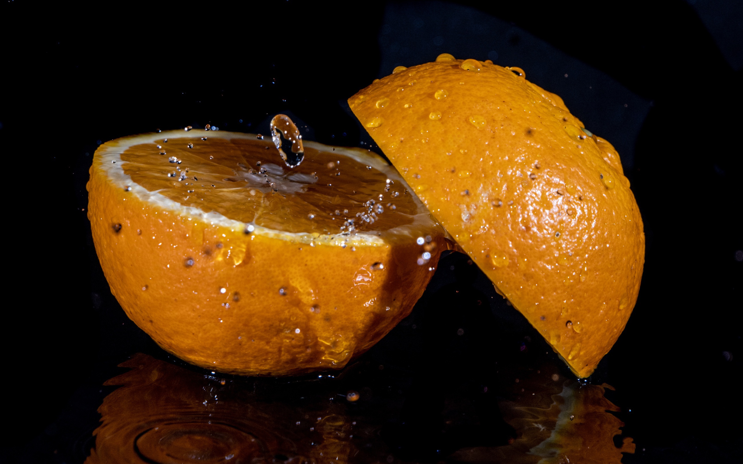 Две половины апельсина на черном фоне 