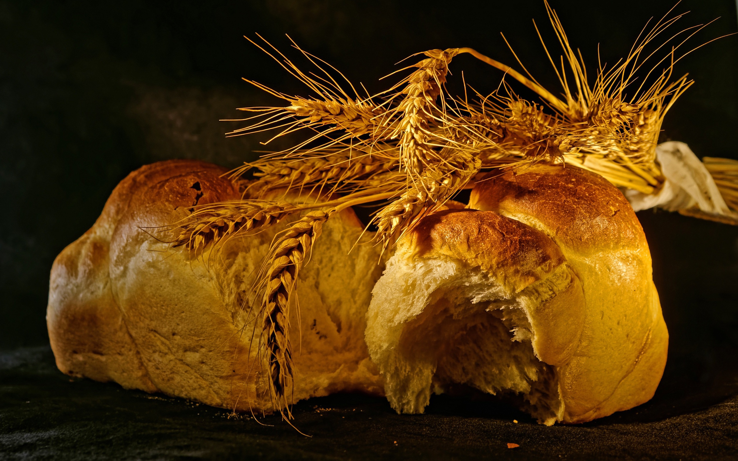 Свежий хлеб с колосьями пшеницы на столе