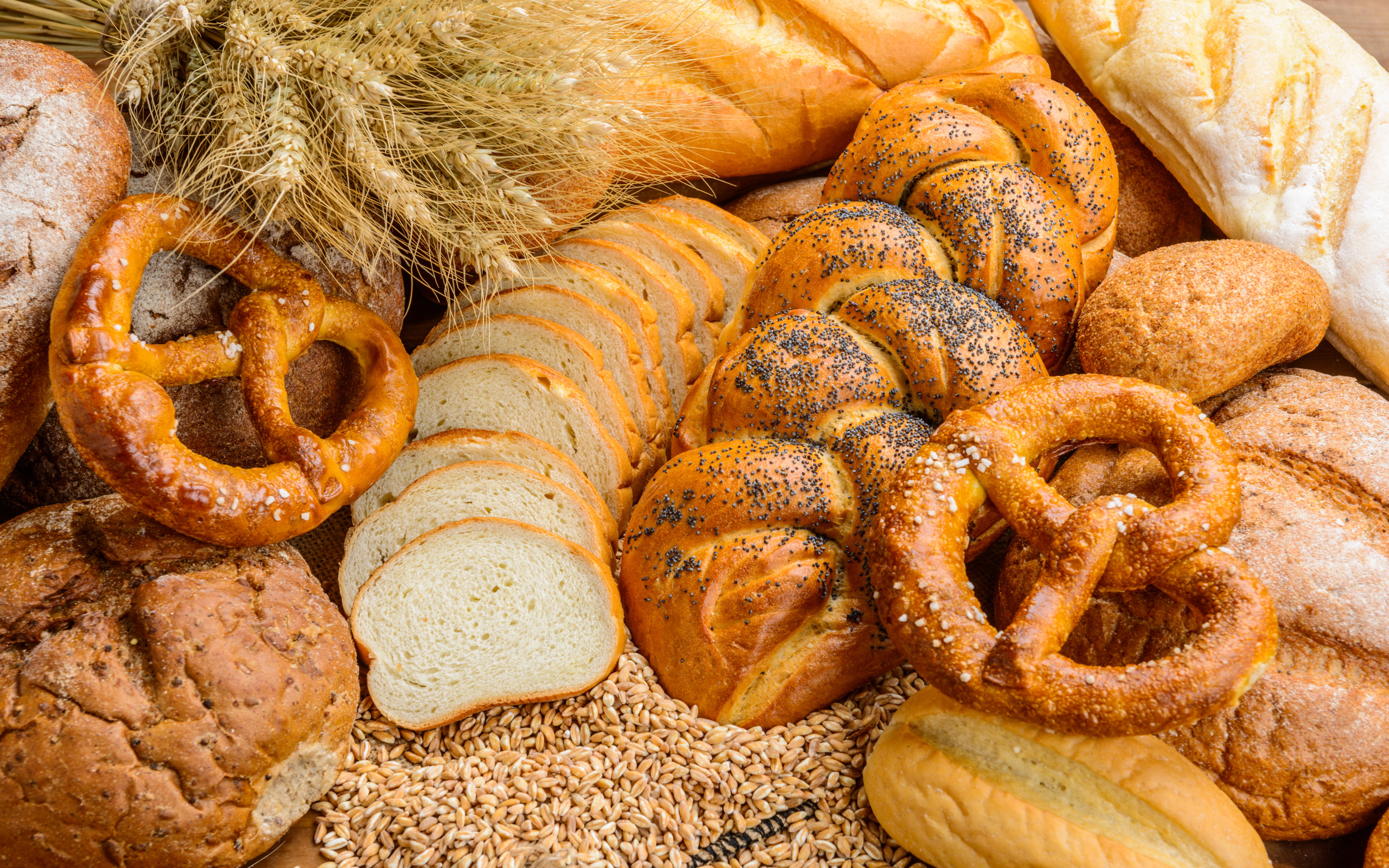 Свежая выпечка на столе с колосьями и зернами пшеницы 