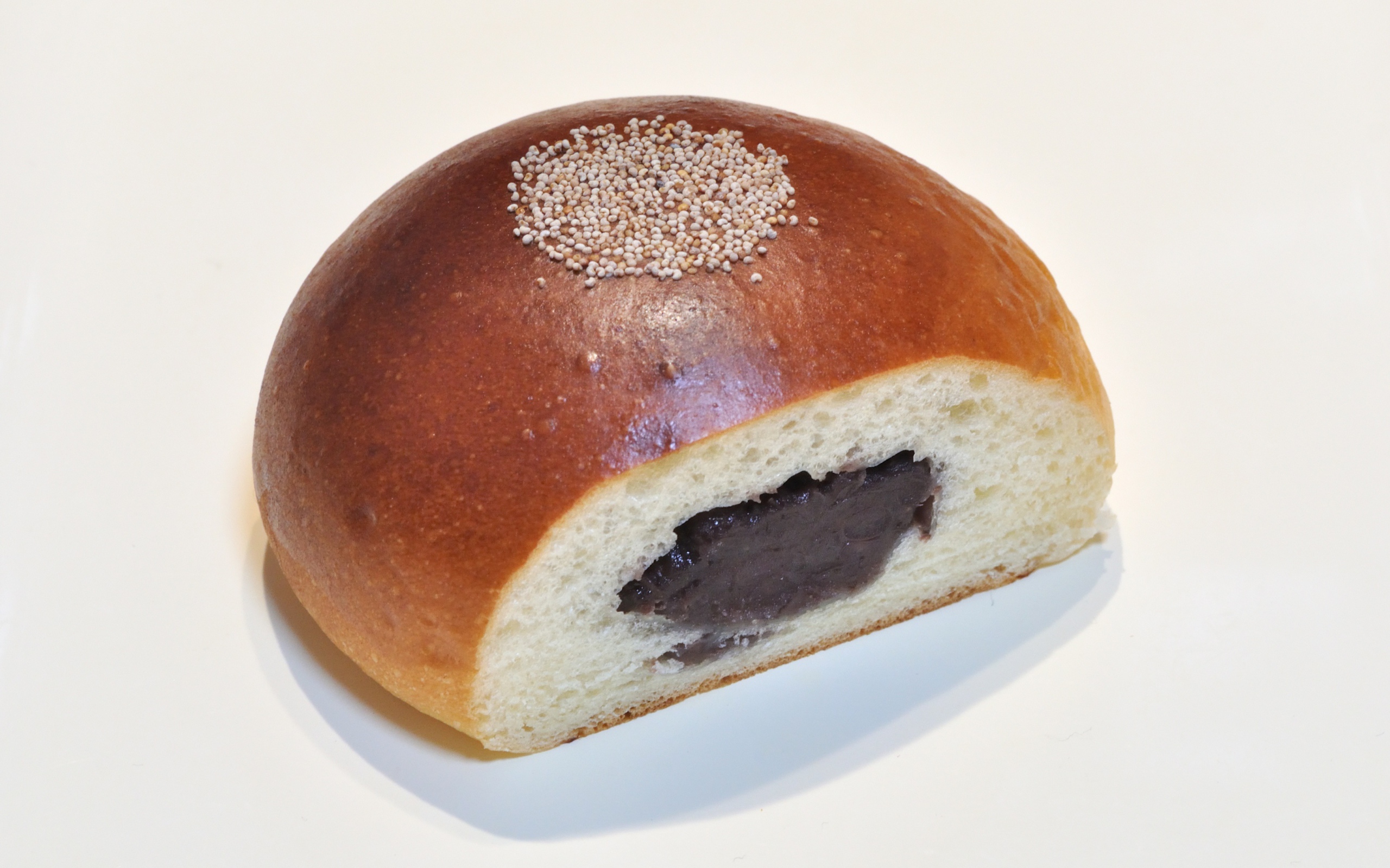 Свежая румяная булочка с вареньем на белом фоне