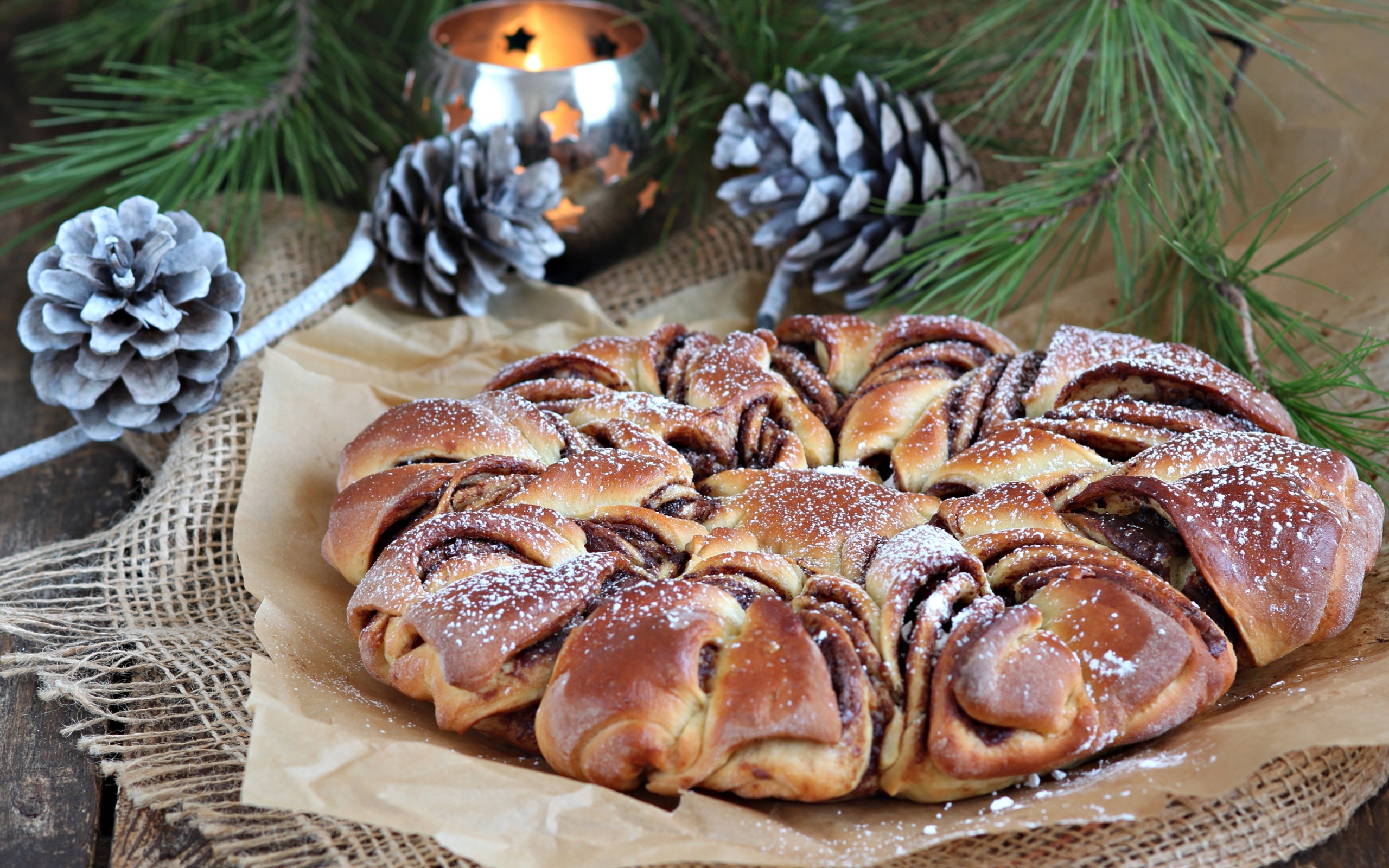 Сдобный венок с вареньем на столе с шишками