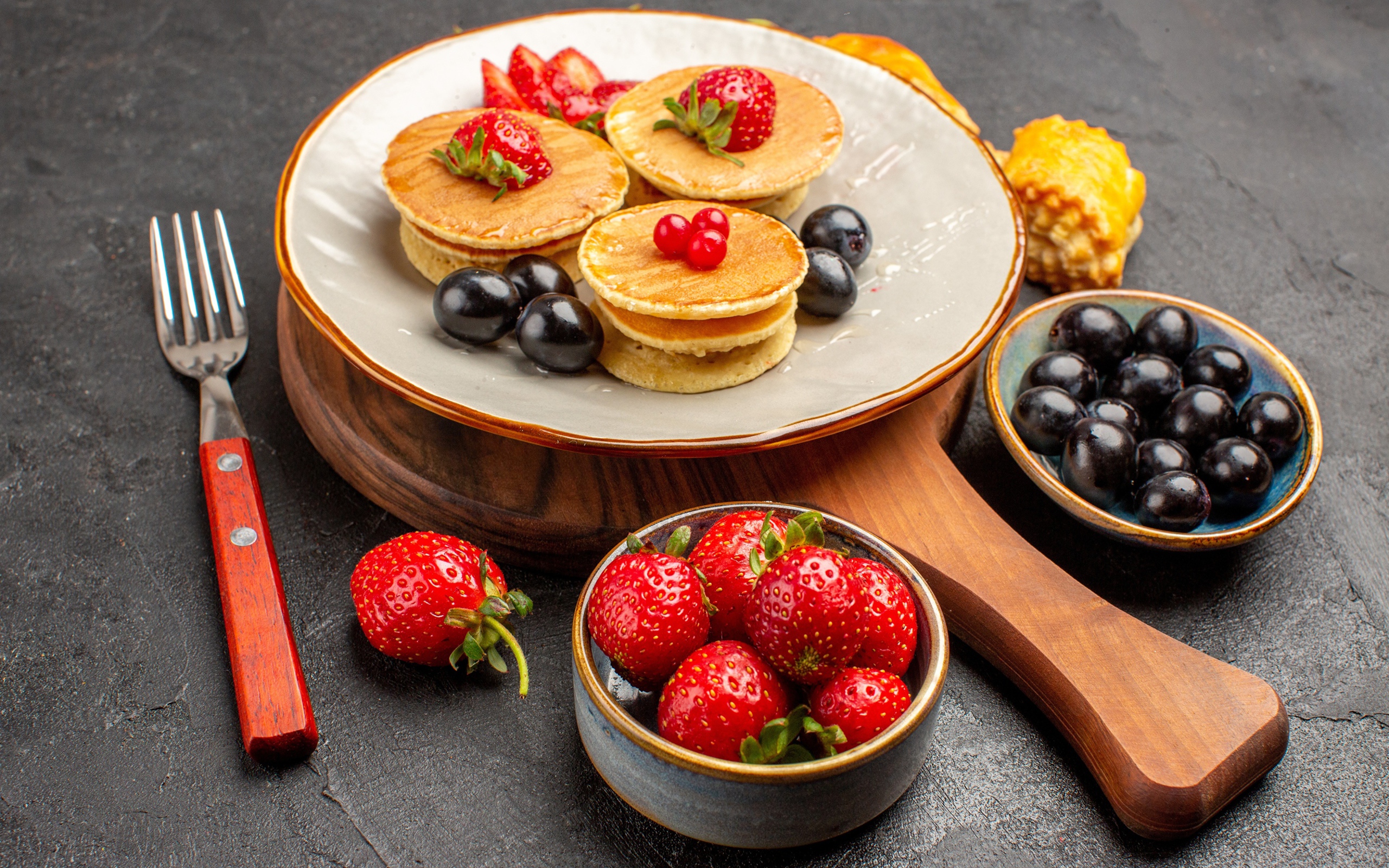 Оладьи с виноградом и клубникой на тарелке 