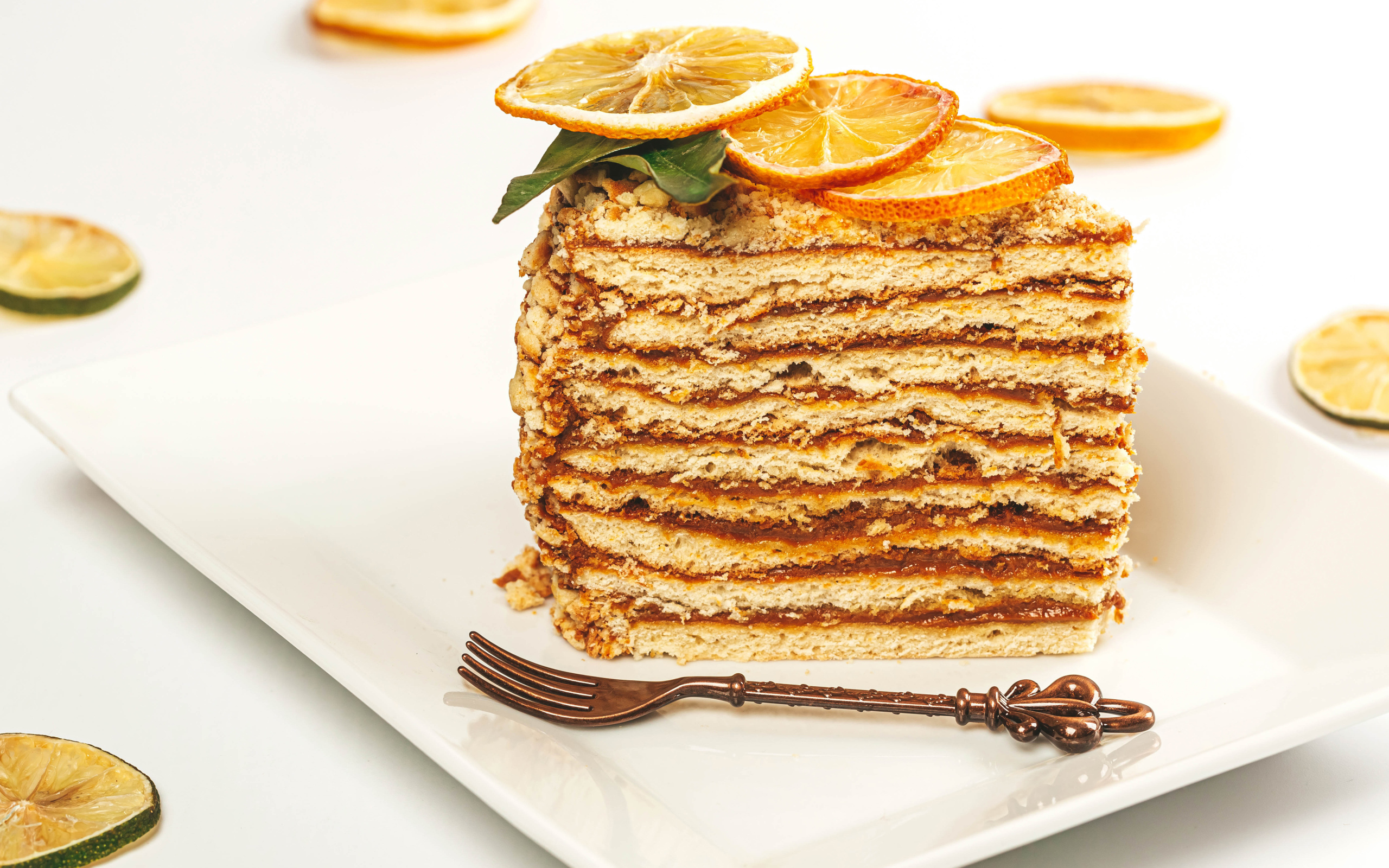 Кусок торт с сушеными лимонами на белой тарелке