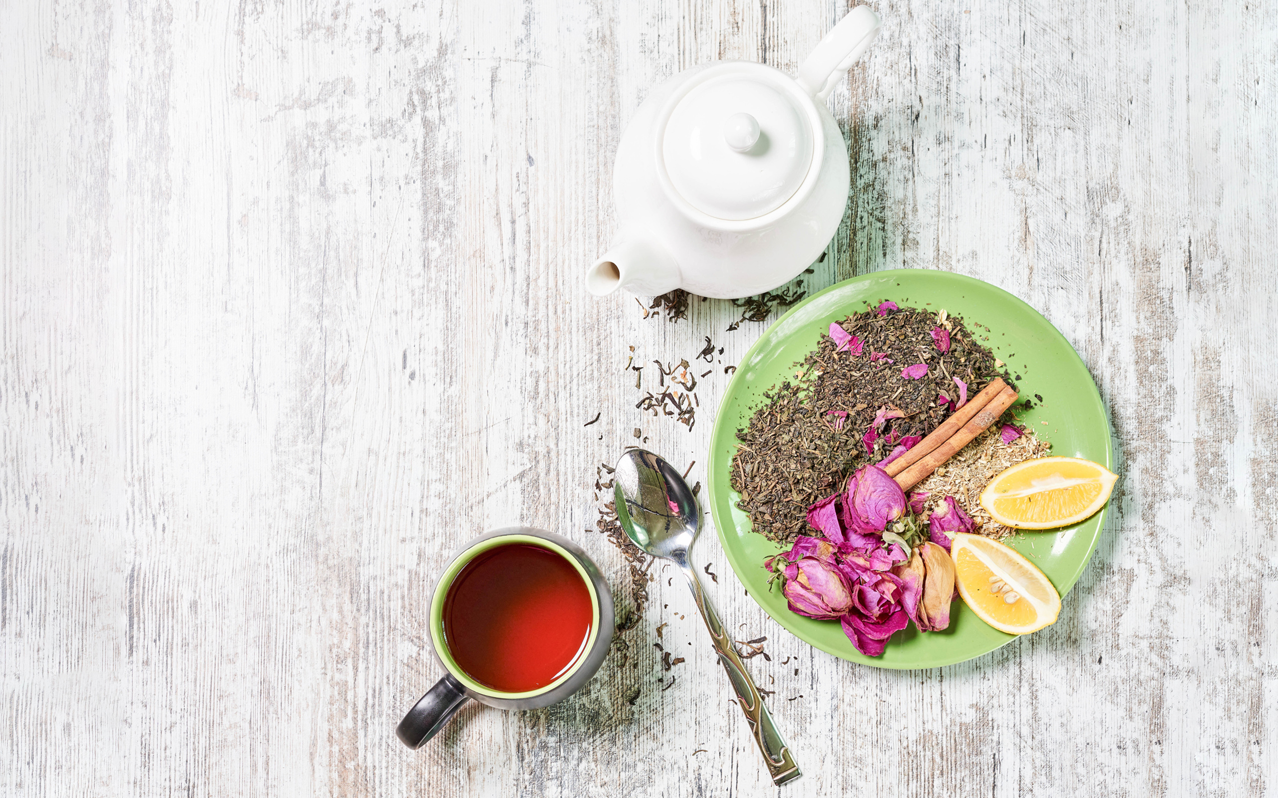 Чай на тарелке с кусочками лимона на столе