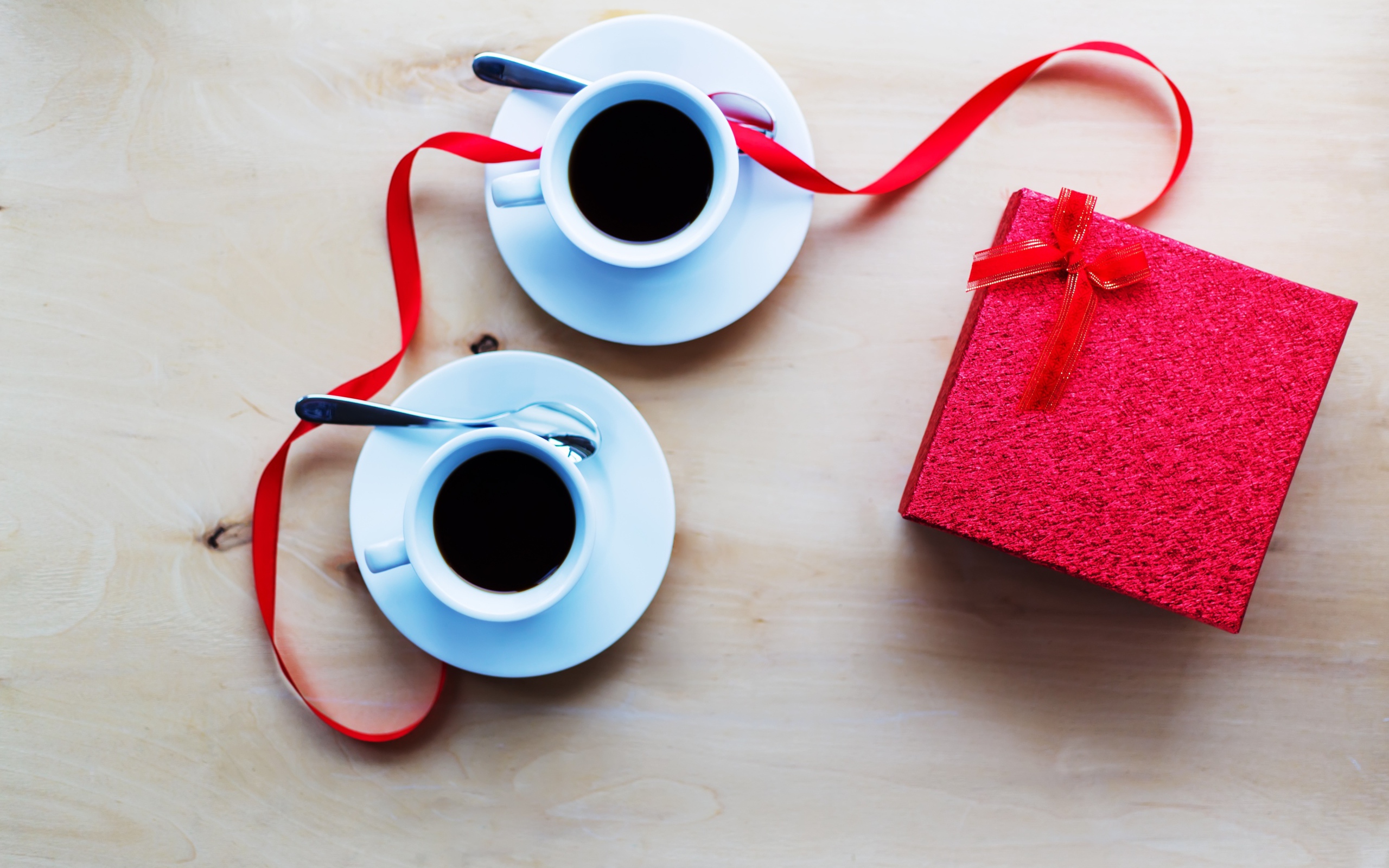 Две чашки кофе на столе с подарком