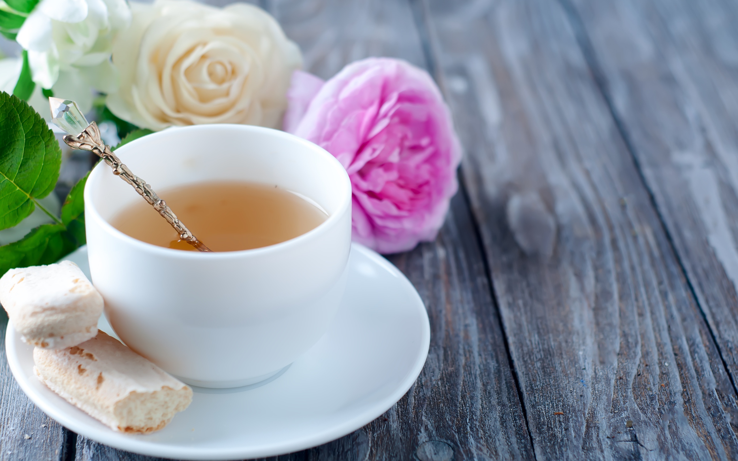 Белая чашка чая на деревянном  столе с розами