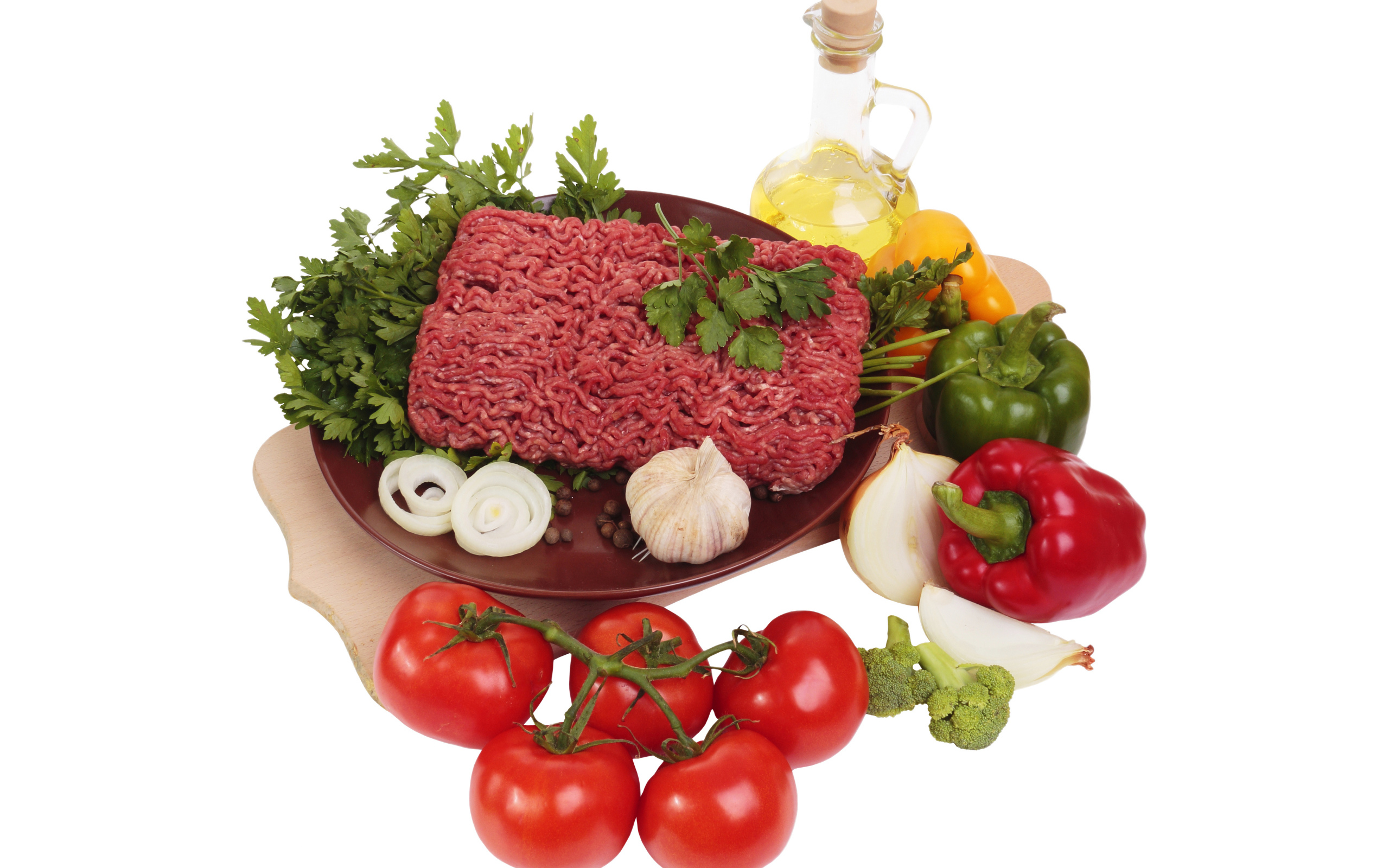 Minced meat on a white plate with vegetables and herbs