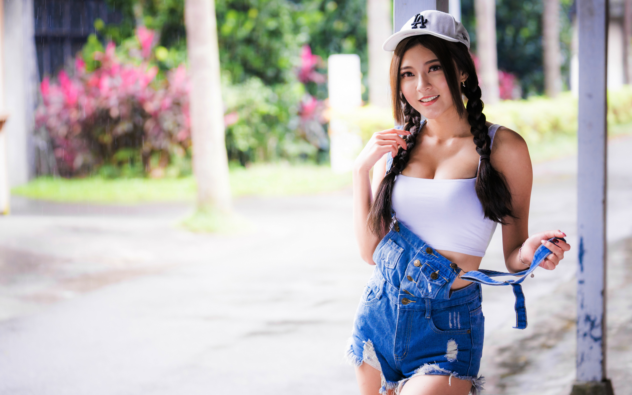 Девушка азиатка в кепке у стены