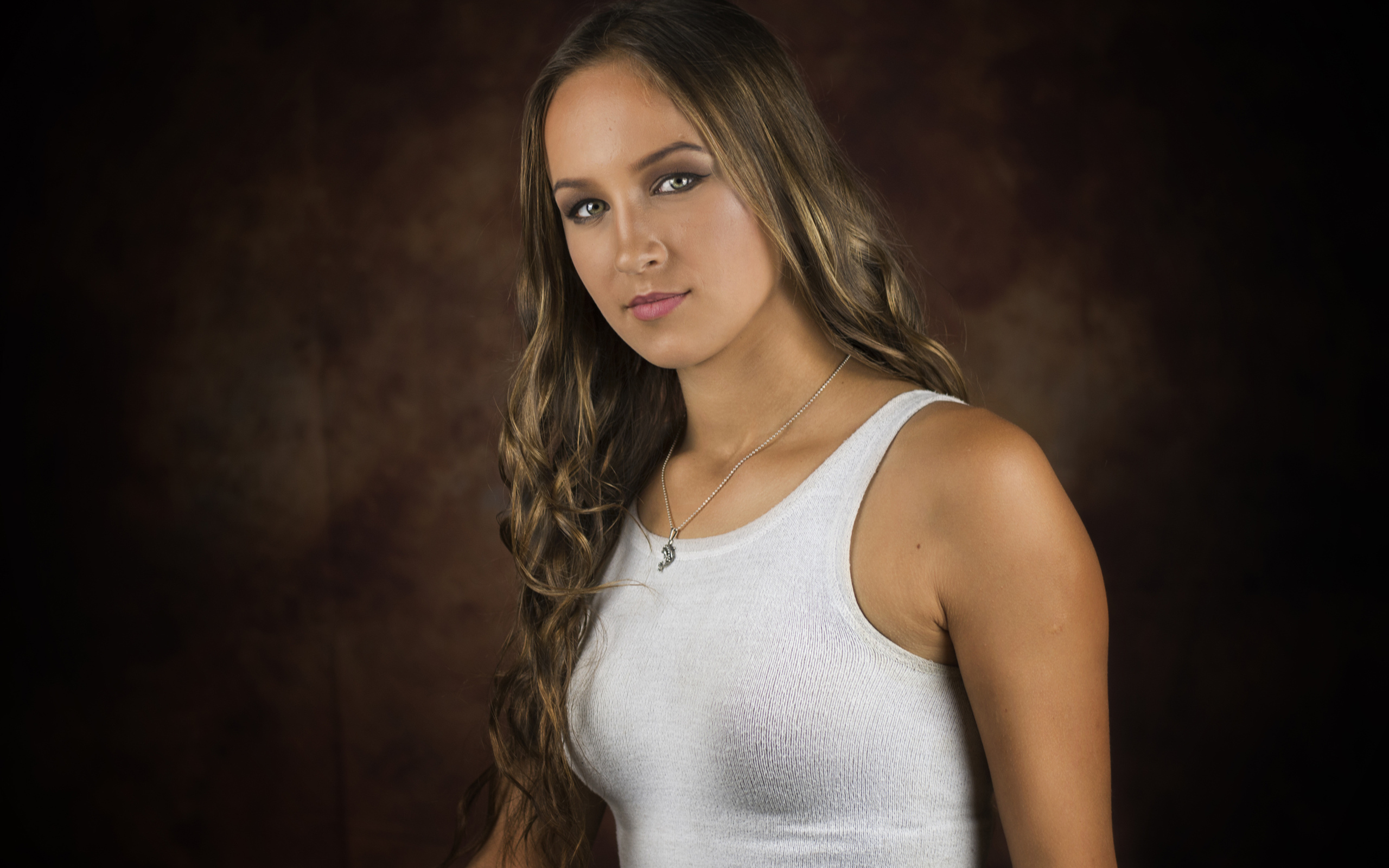 Красивая молодая девушка с длинными волосами в белой майке 