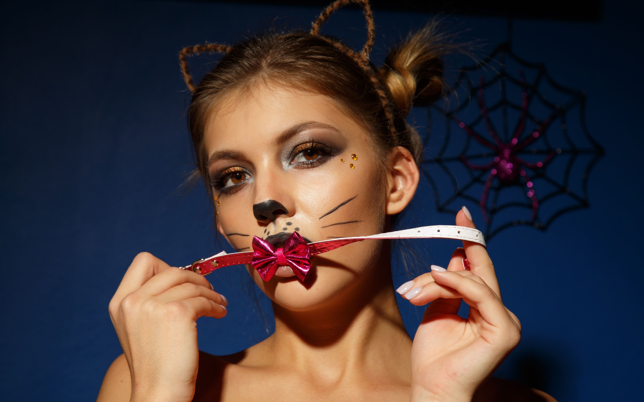 Девушка кошка с красным бантиком во рту 