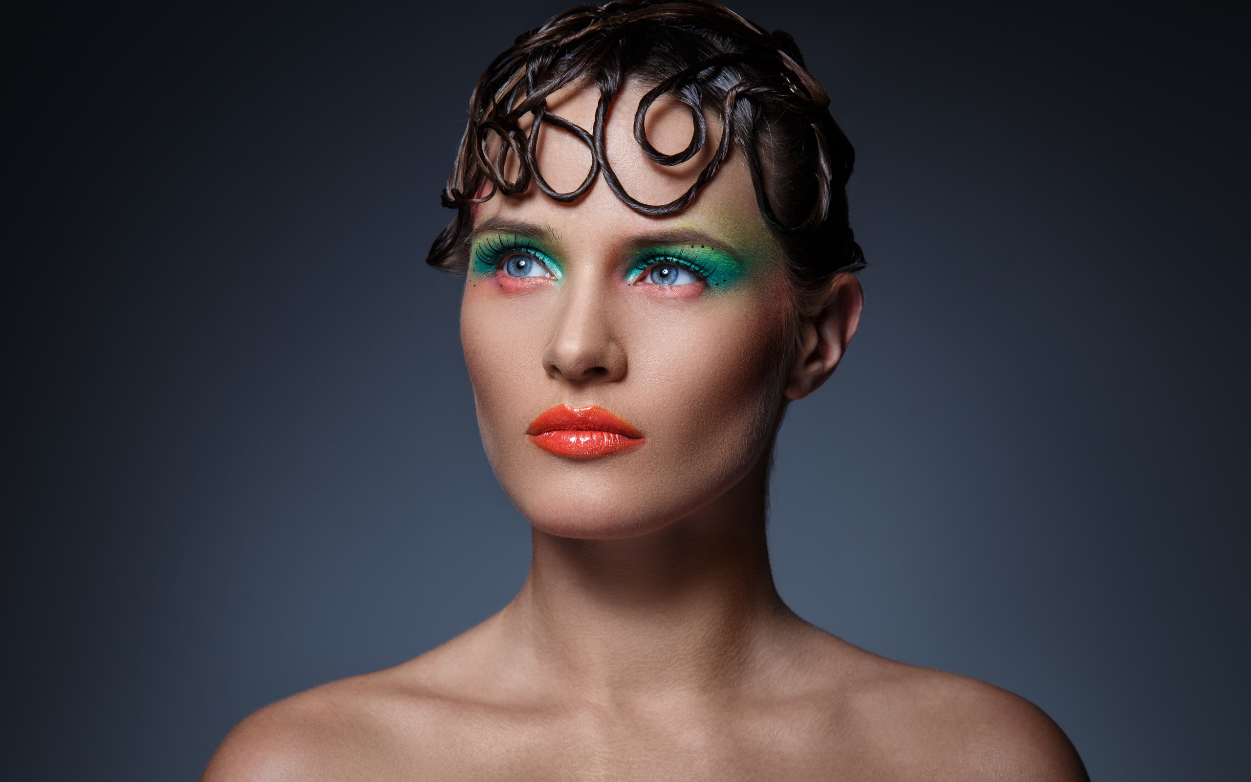 Девушка с ярким макияжем на сером фоне 