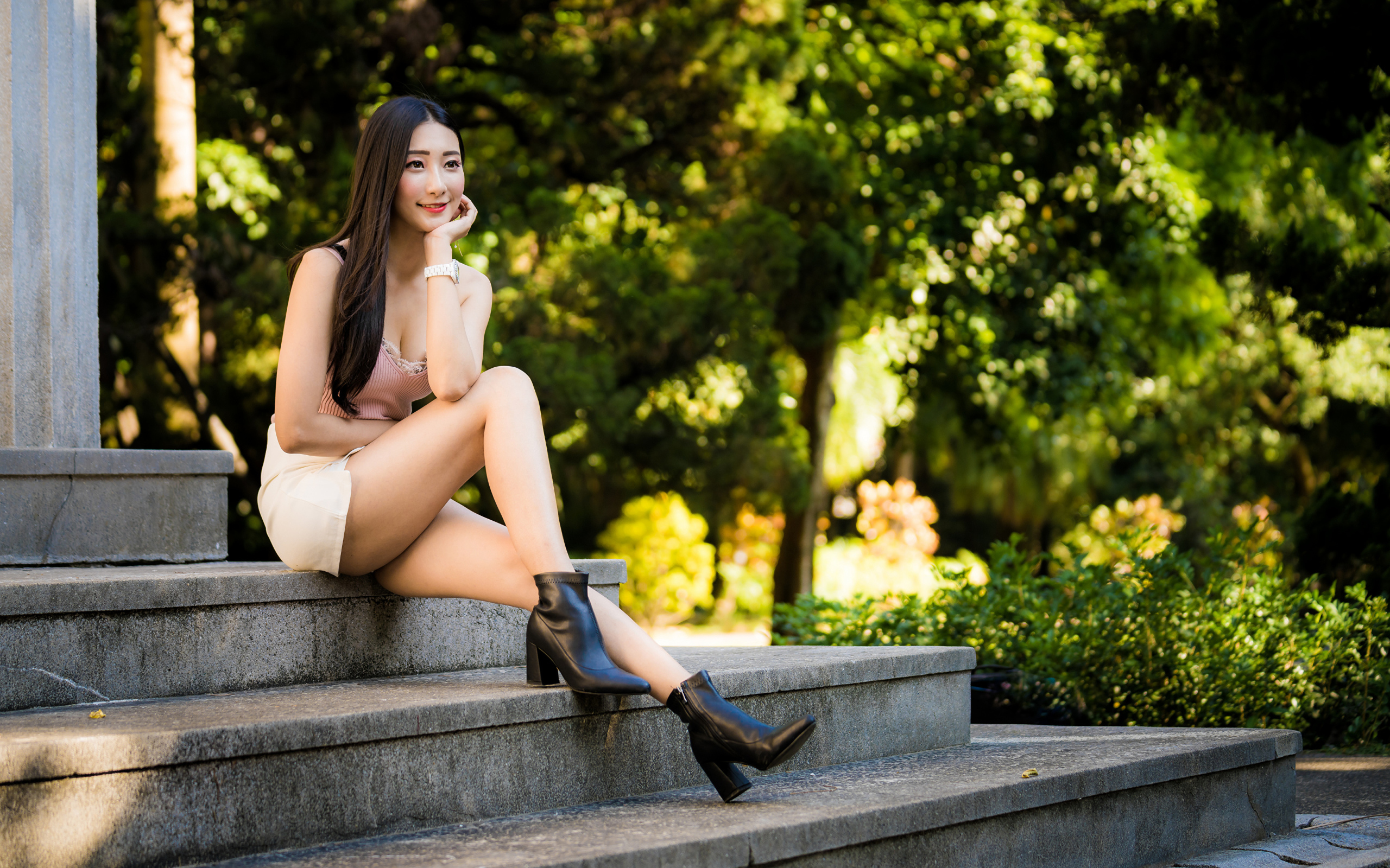 Улыбающаяся азиатка сидит на ступеньках