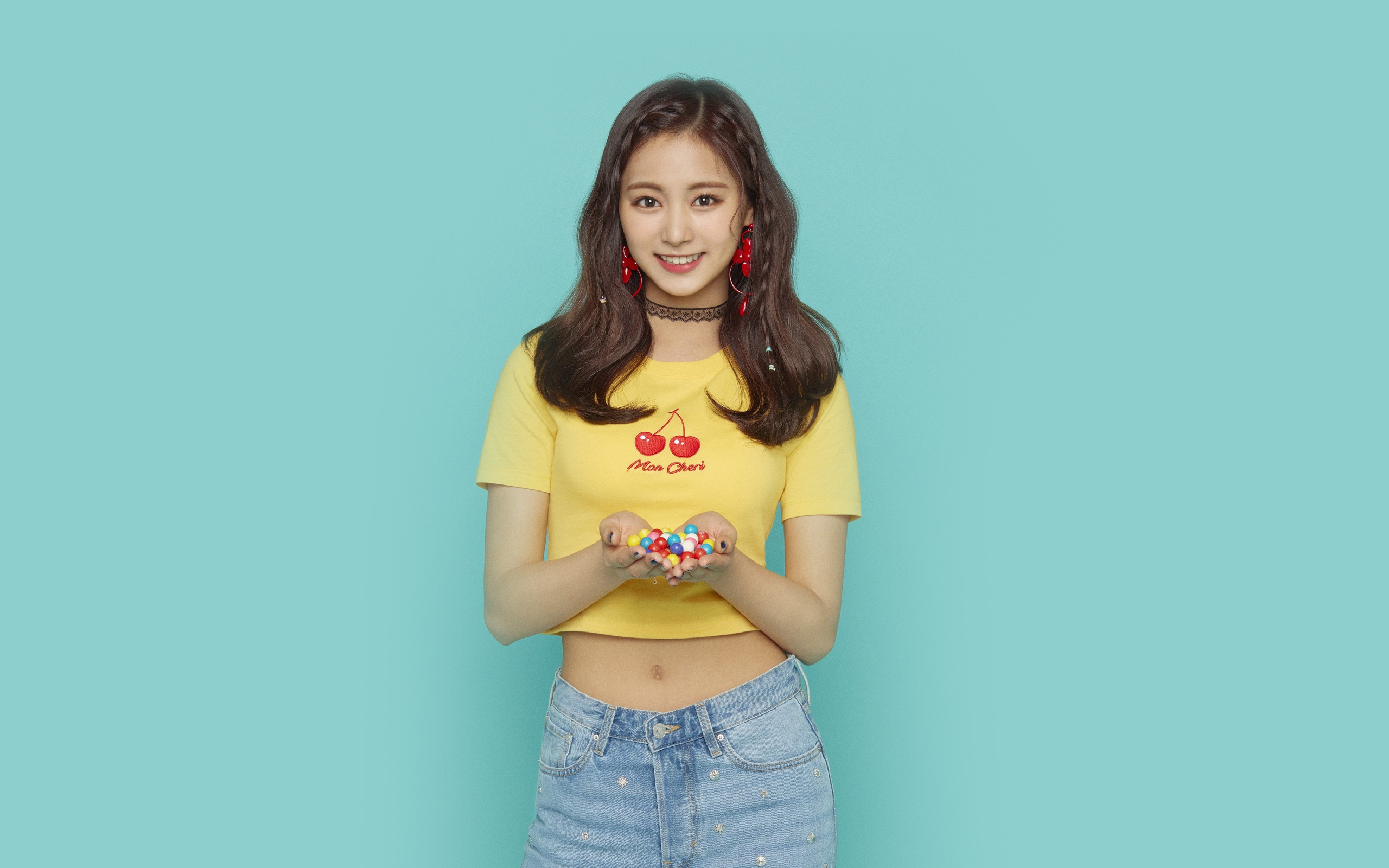 Улыбающаяся девушка с конфетами в ладонях на голубом фоне 