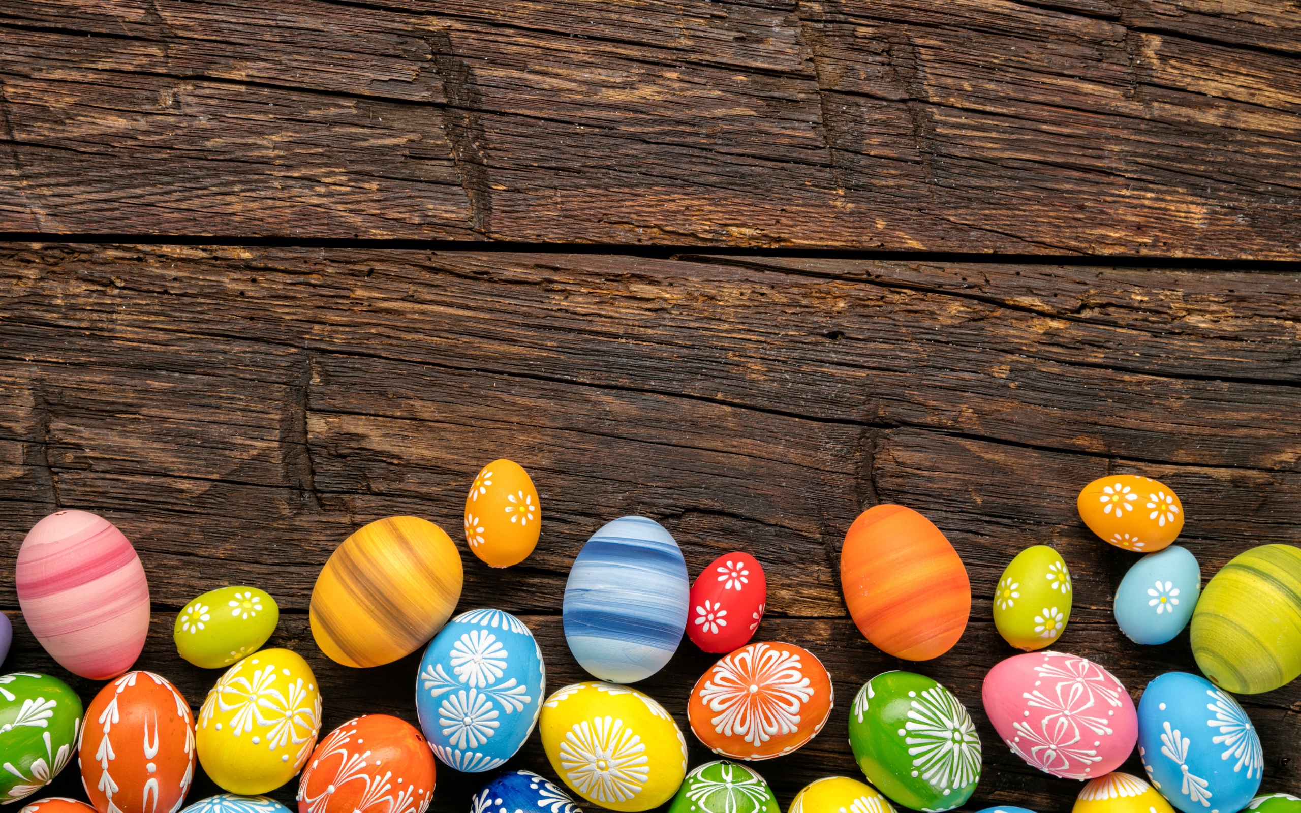 Разноцветные пасхальные яйца на деревянном столе