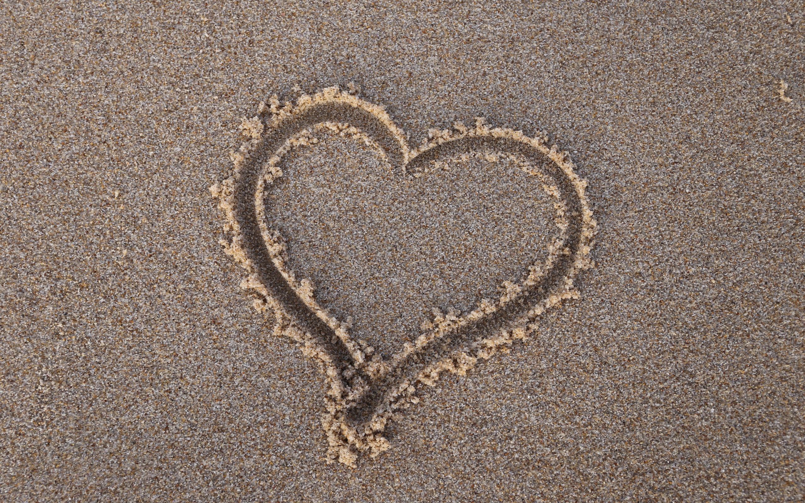 Сердце нарисовано на мокром песке 