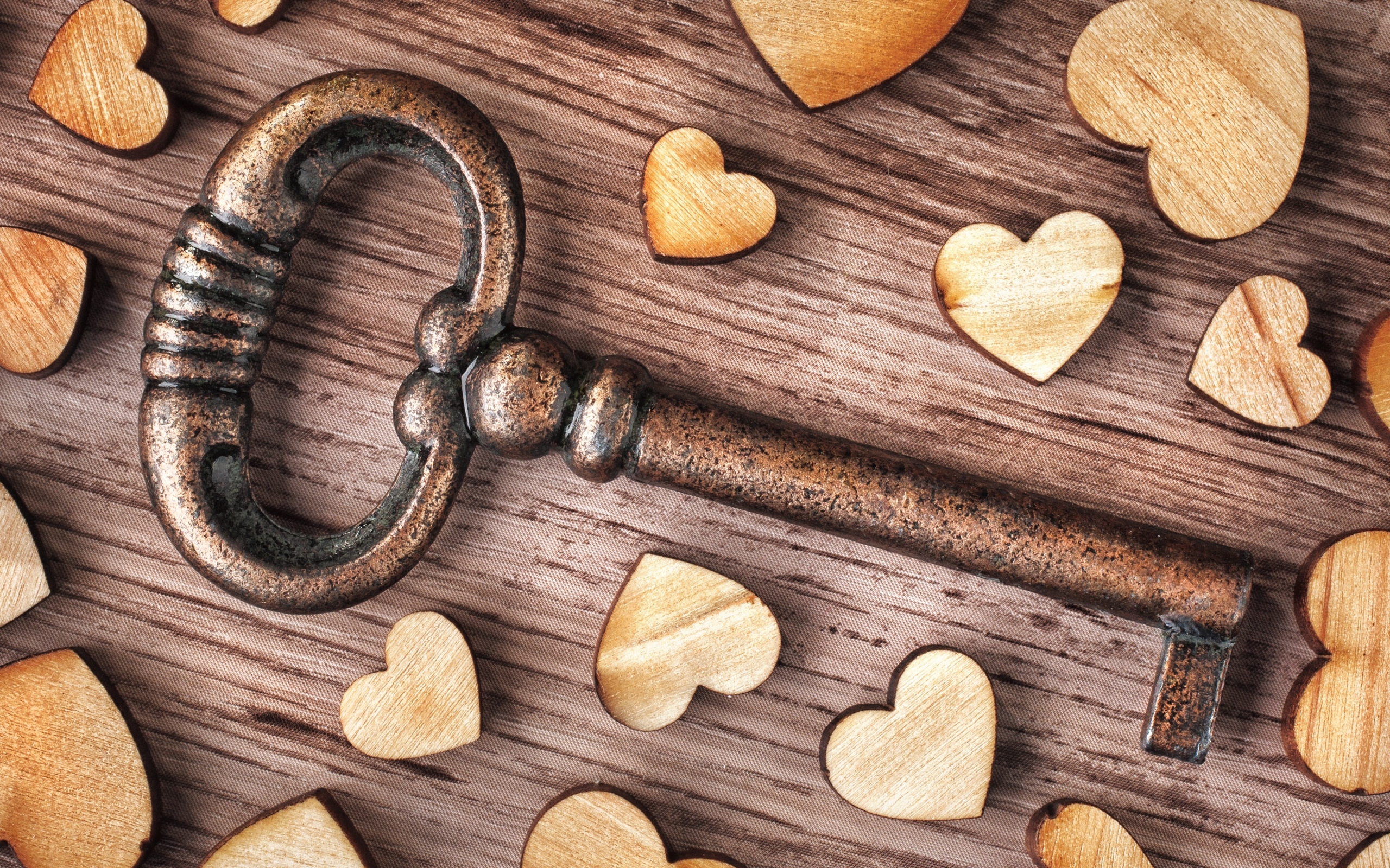 Wooden hearts on a table with a key