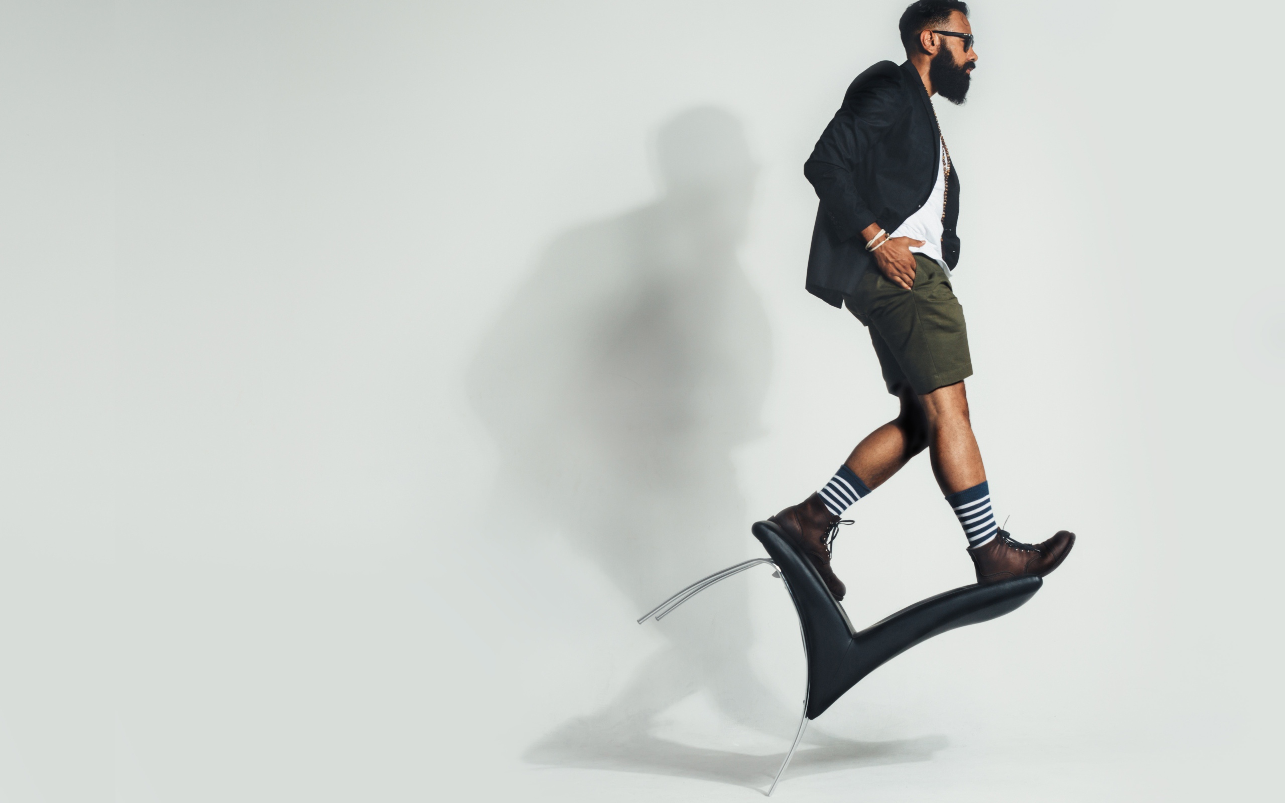 Мужчина балансирует на черном кресле