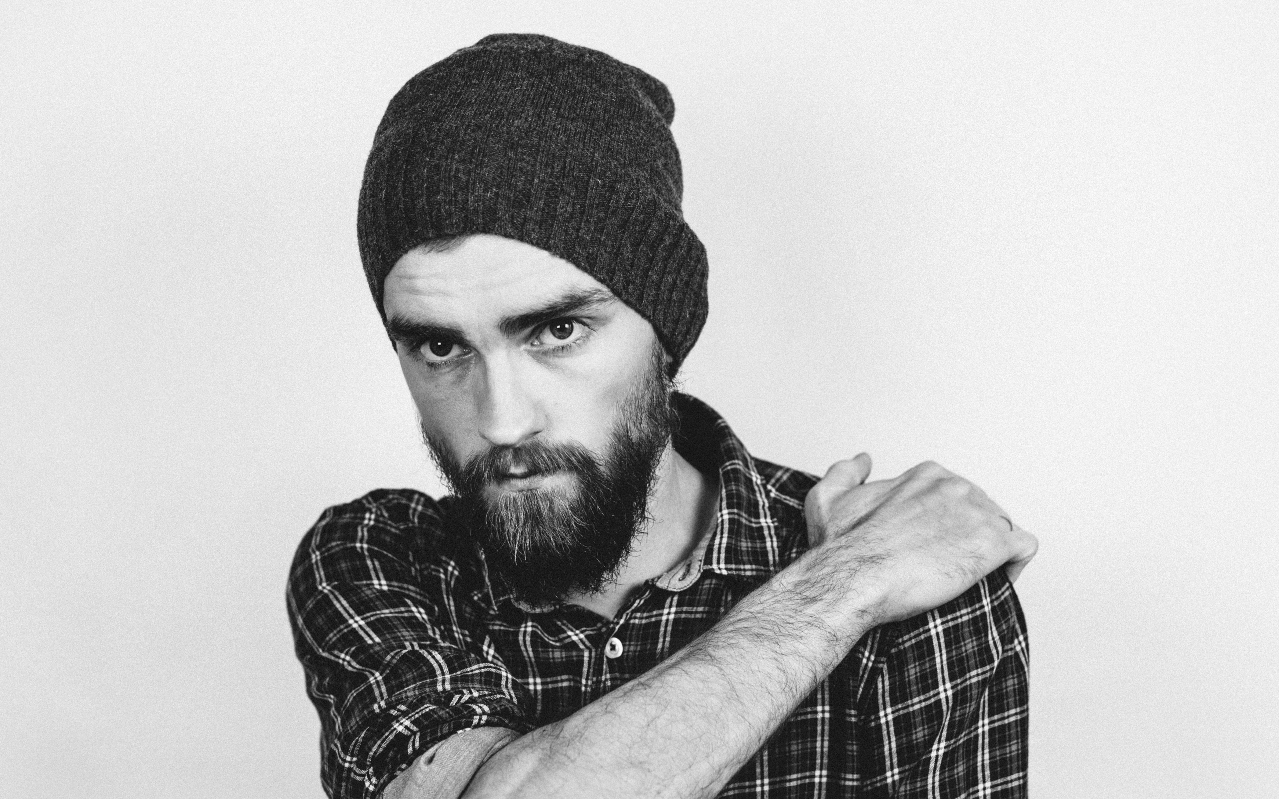 Бородатый мужчина в шапке на белом фоне 